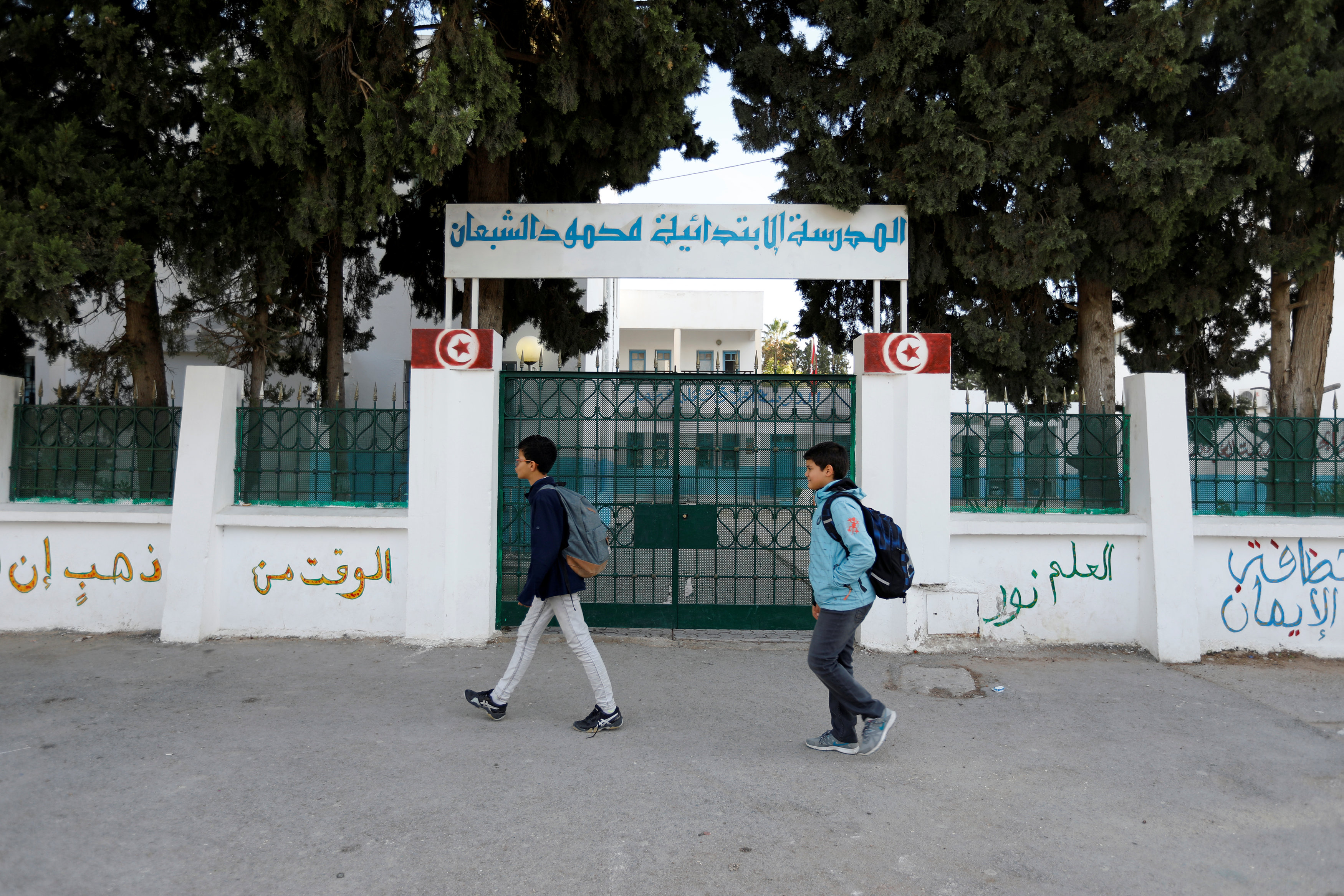 أطفال تونسيون يسيرون أمام أحد المدارس المغلقة بسبب الإضراب