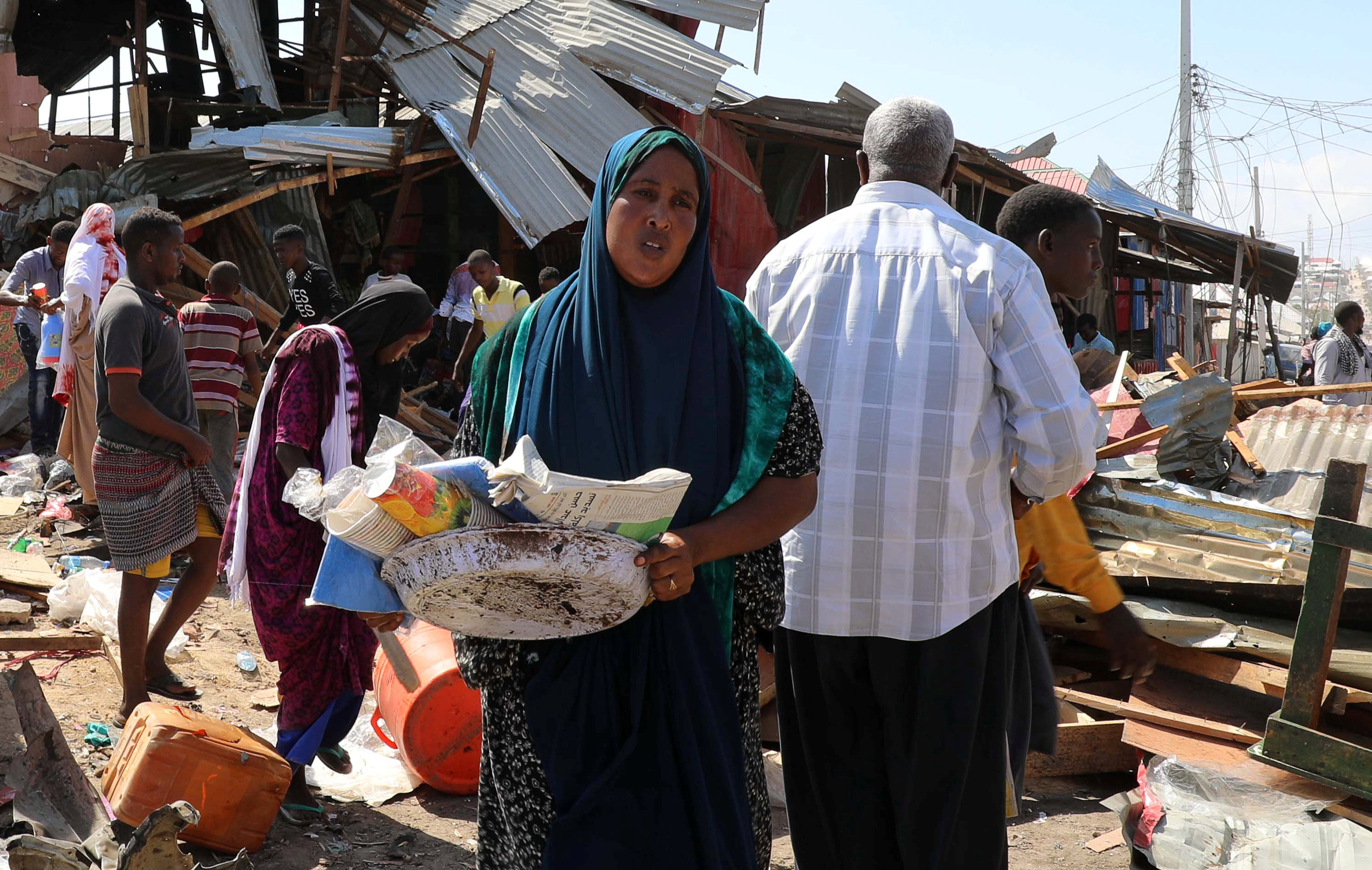 سيدة صومالية تجمع ما تبقى من متجرها بعد تدميره