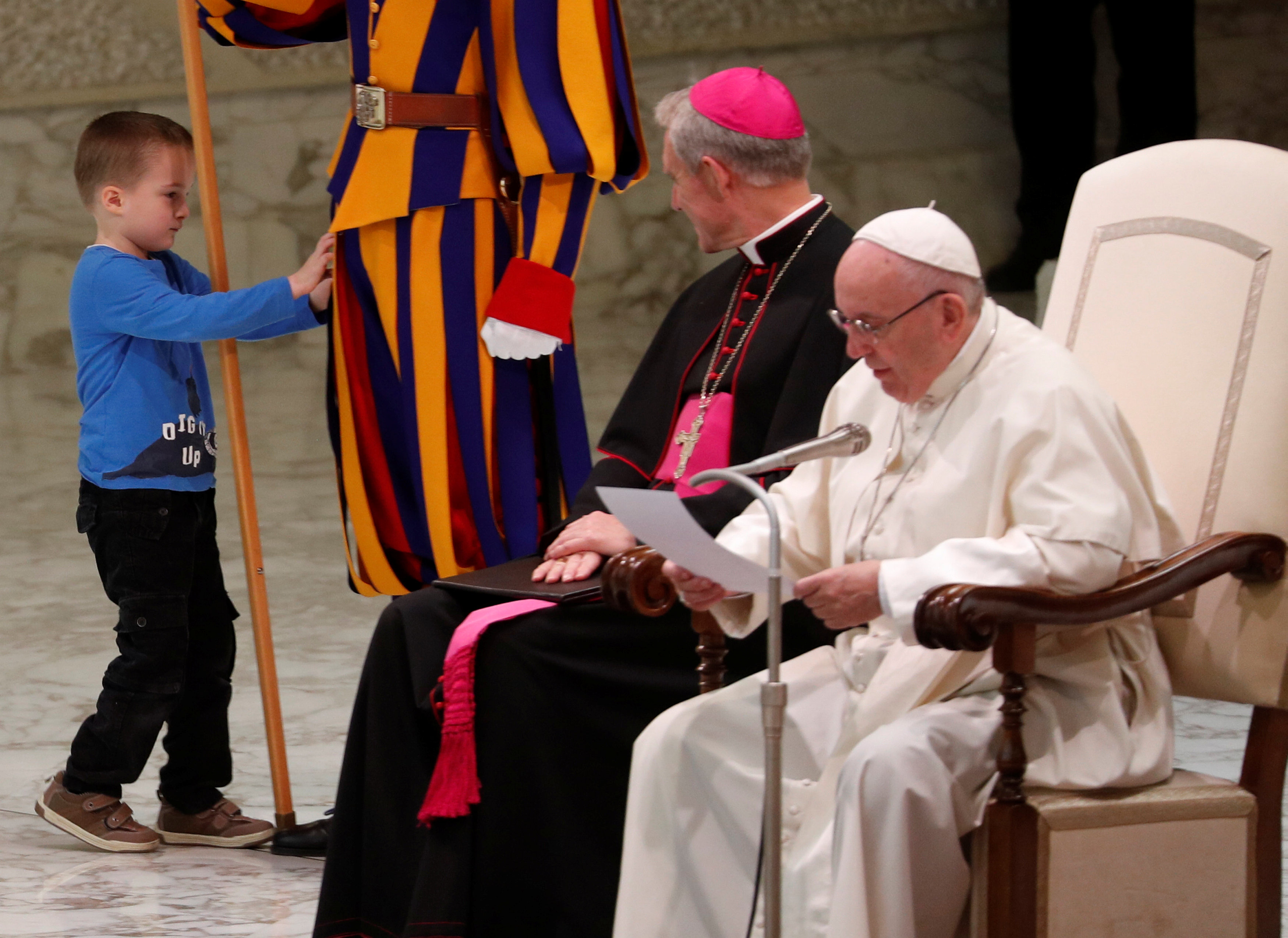طفل يداعب الحارس السويسى للفاتيكان أثناء محاضرة البابا فرنسيس