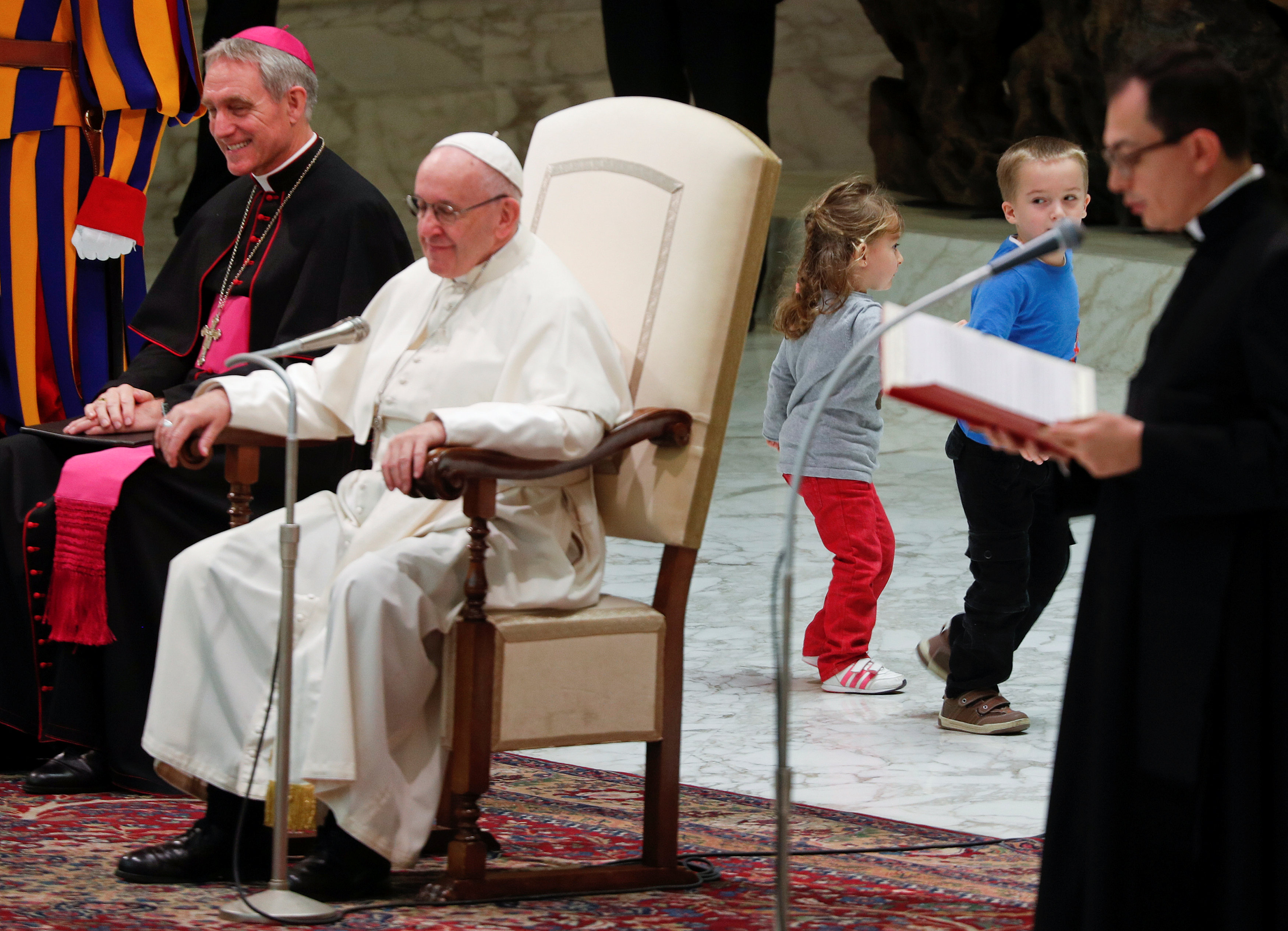 الطفل وصديقته يلعبان وراء كرسى البابا