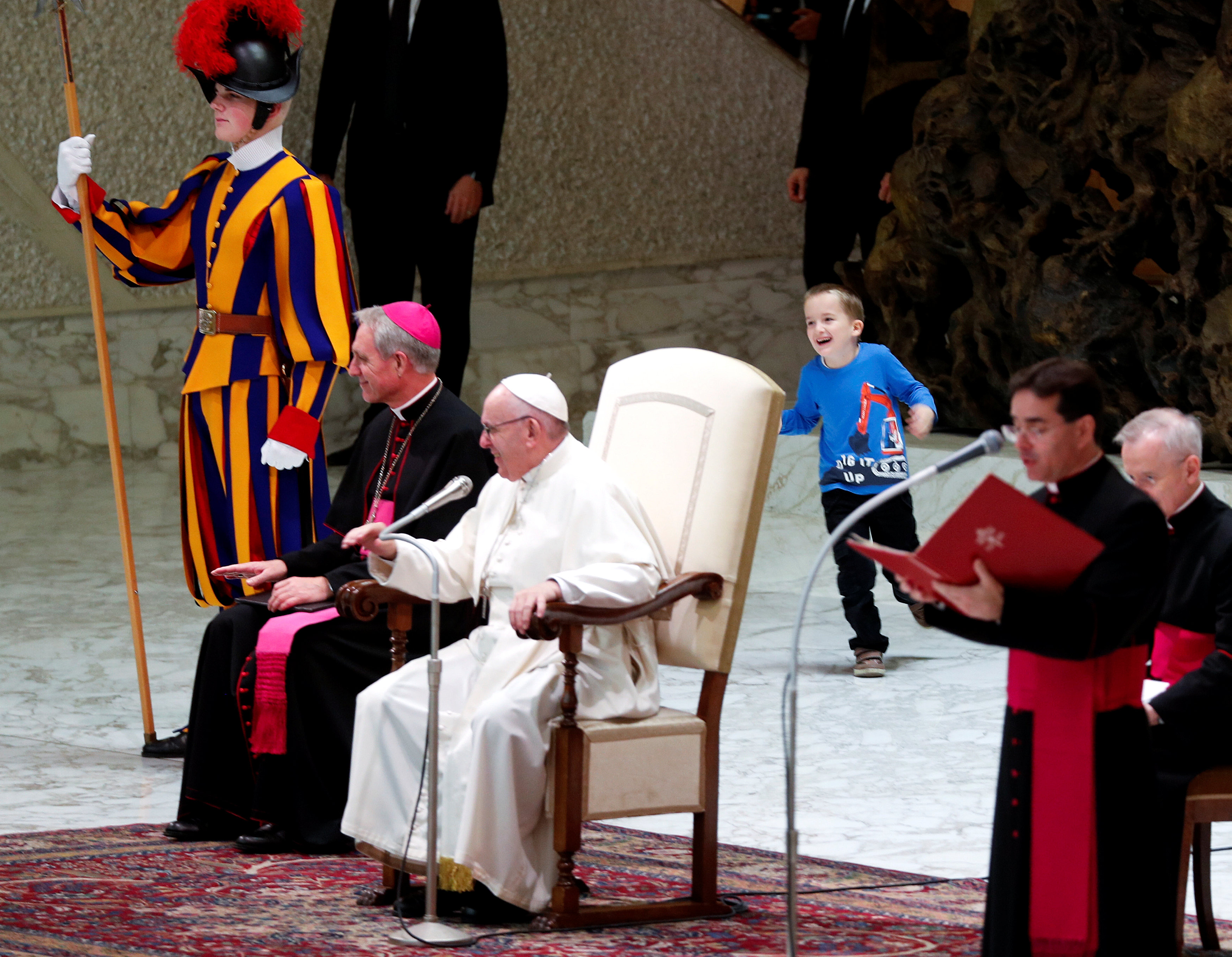 الطفل يلهو خلف كرسى البابا