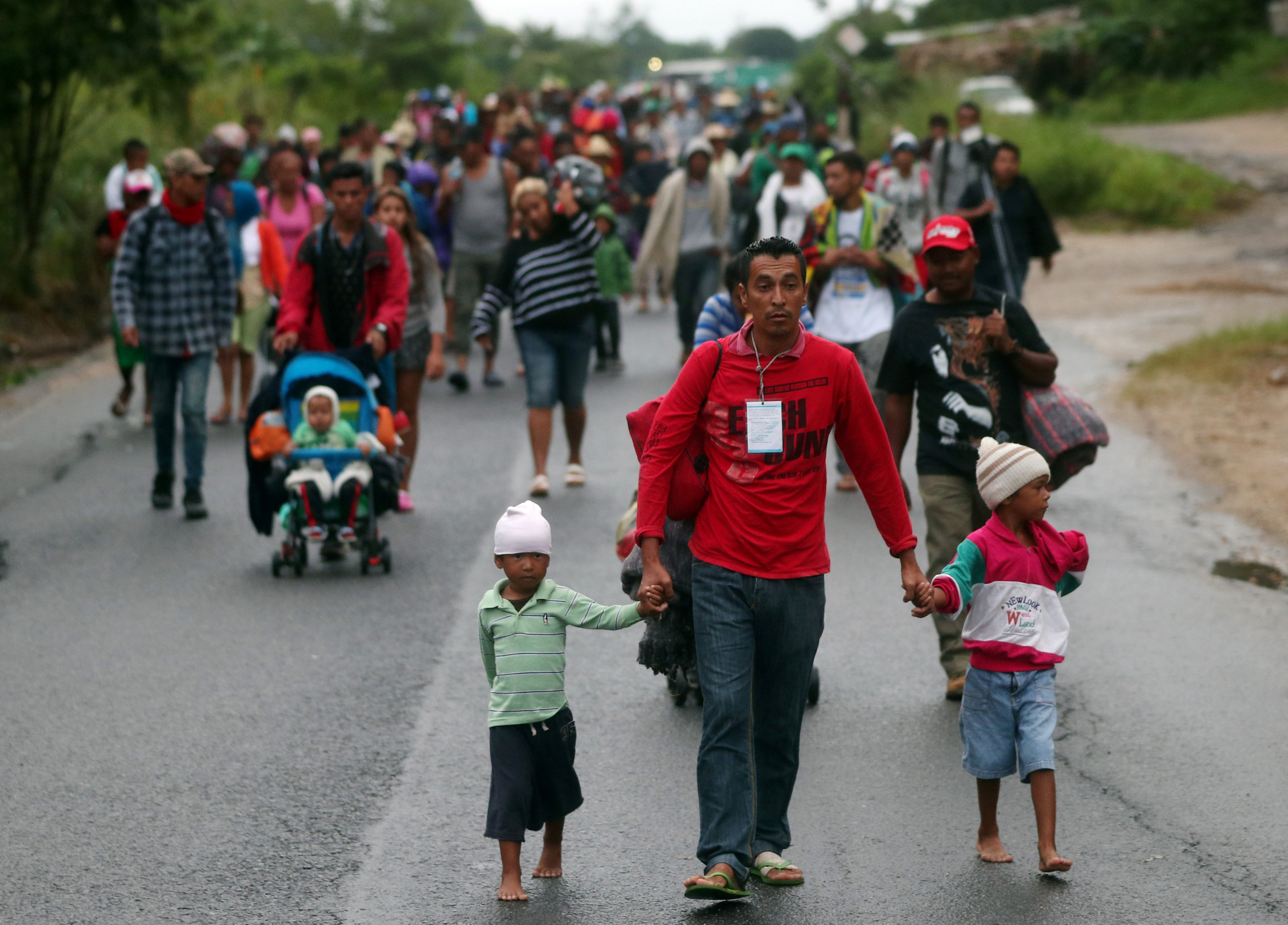 أحد المهاجرين يسير بصحبة ابناءه
