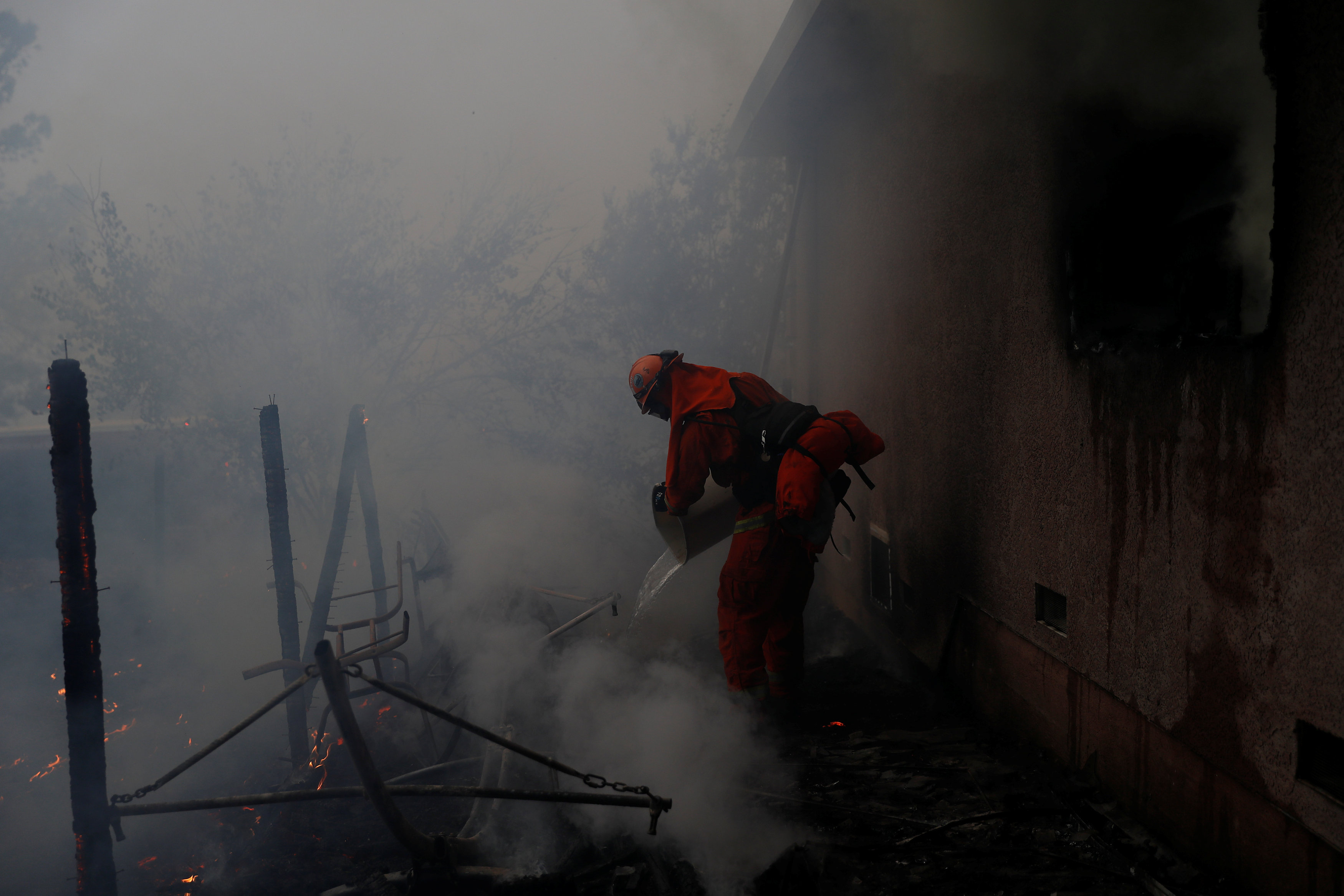 أحد رجال الإنقاذ يطفئ النيران