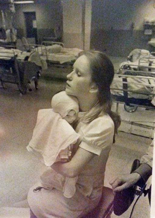 الممرضة تحتضن الرضيعة