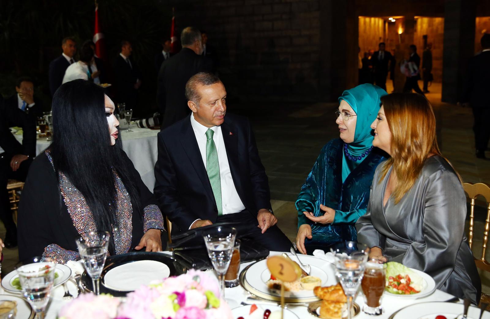 الرئيس التركي رجب طيب أردوغان وزوجته أمينة أردوغان مع الممثلة التركية الشهيرة بولنت أرسوي (إلى اليسار) والمغنية سيبل جان (إلى اليمين) في عشاء رمضاني في إسطنبول في عام 2016.