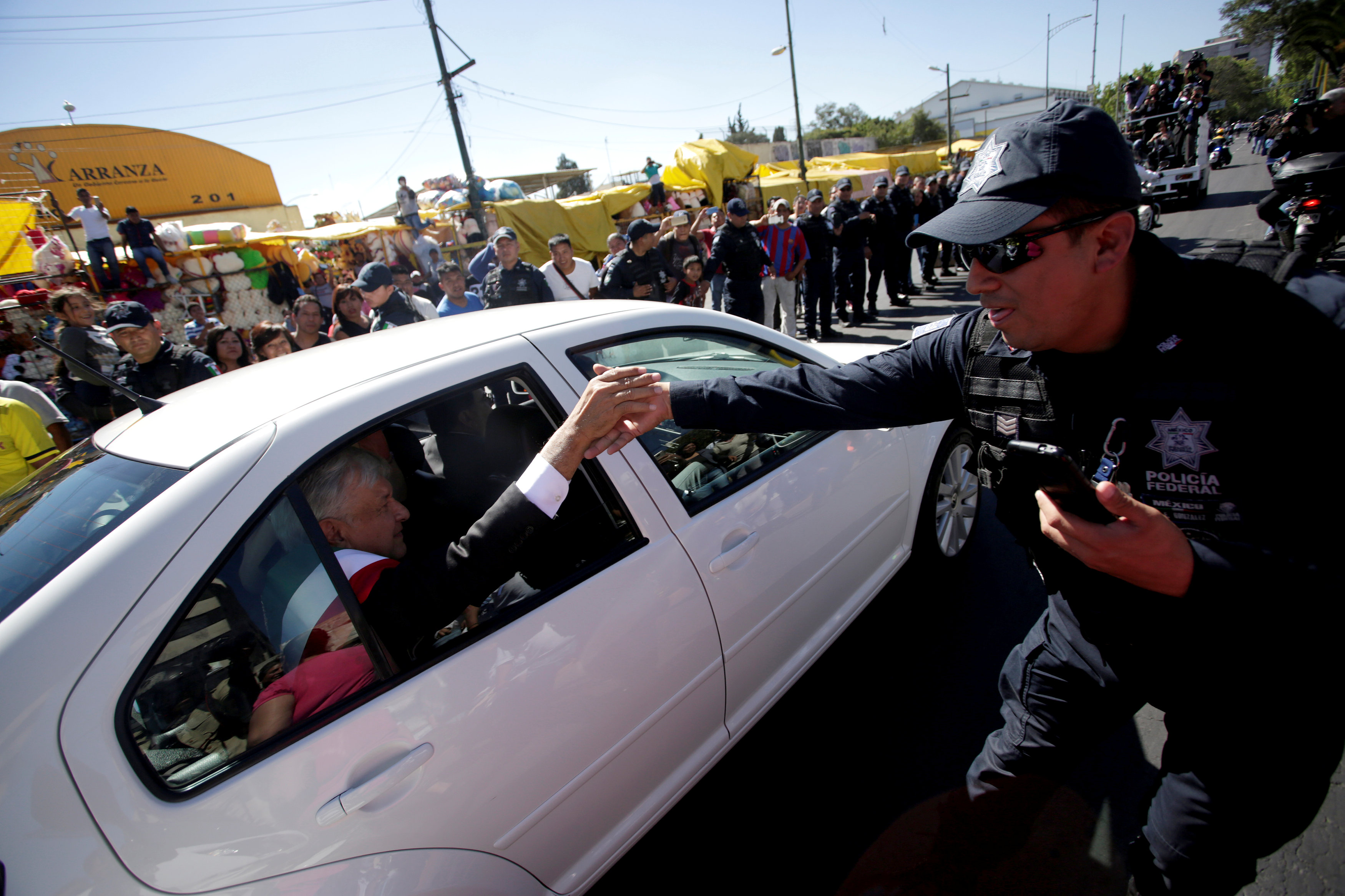 ضابط شرطة فيدرالي يصافح الرئيس الجديد للمكسيك