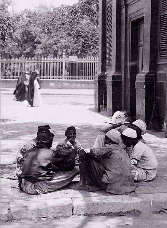 مجموعة من الصبية يجلسون أمام حديقة الأزبكية عام 1900