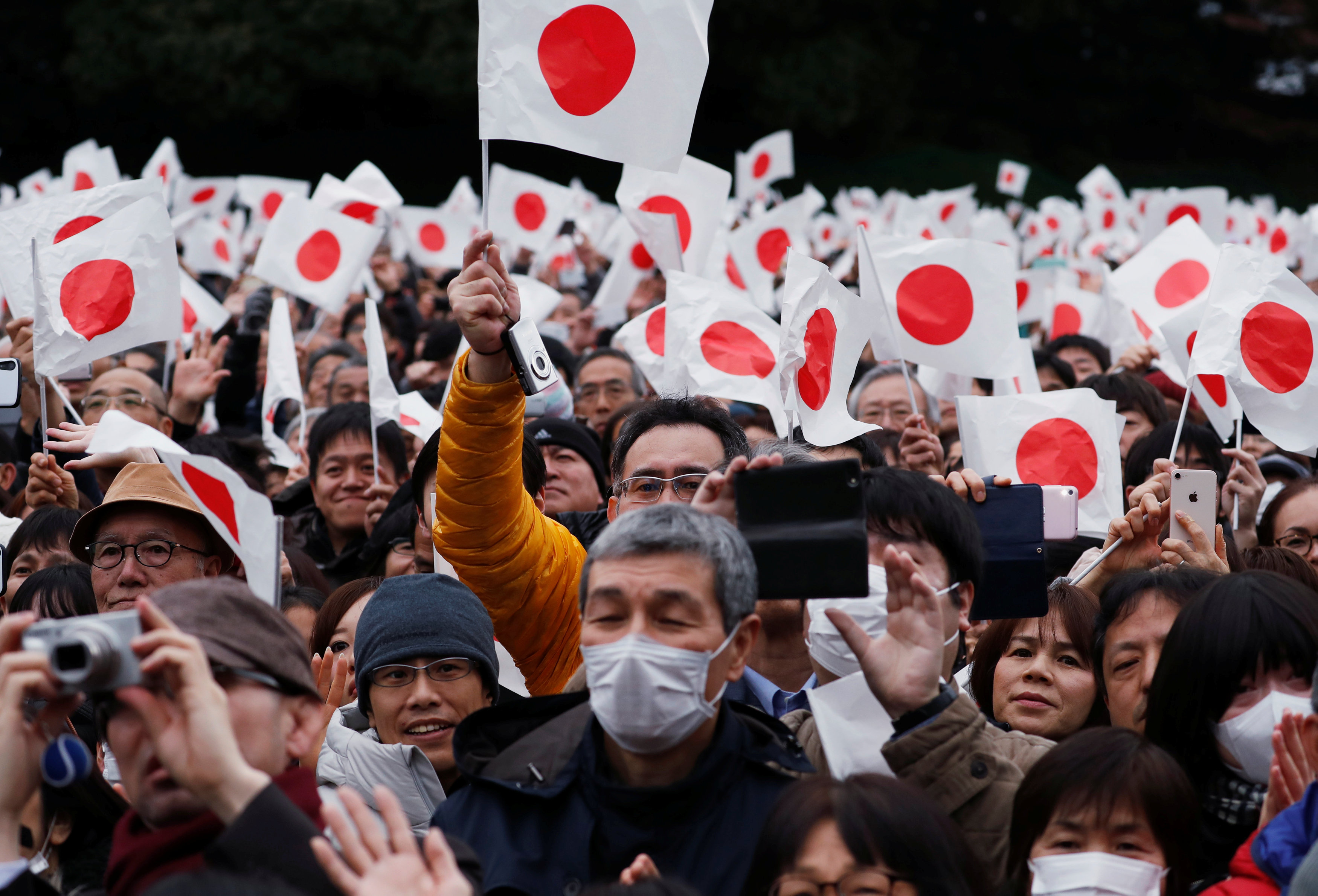 مواطنو اليابان يلوحون بالأعلام احتفالا بعيد ميلاد الامبراطور
