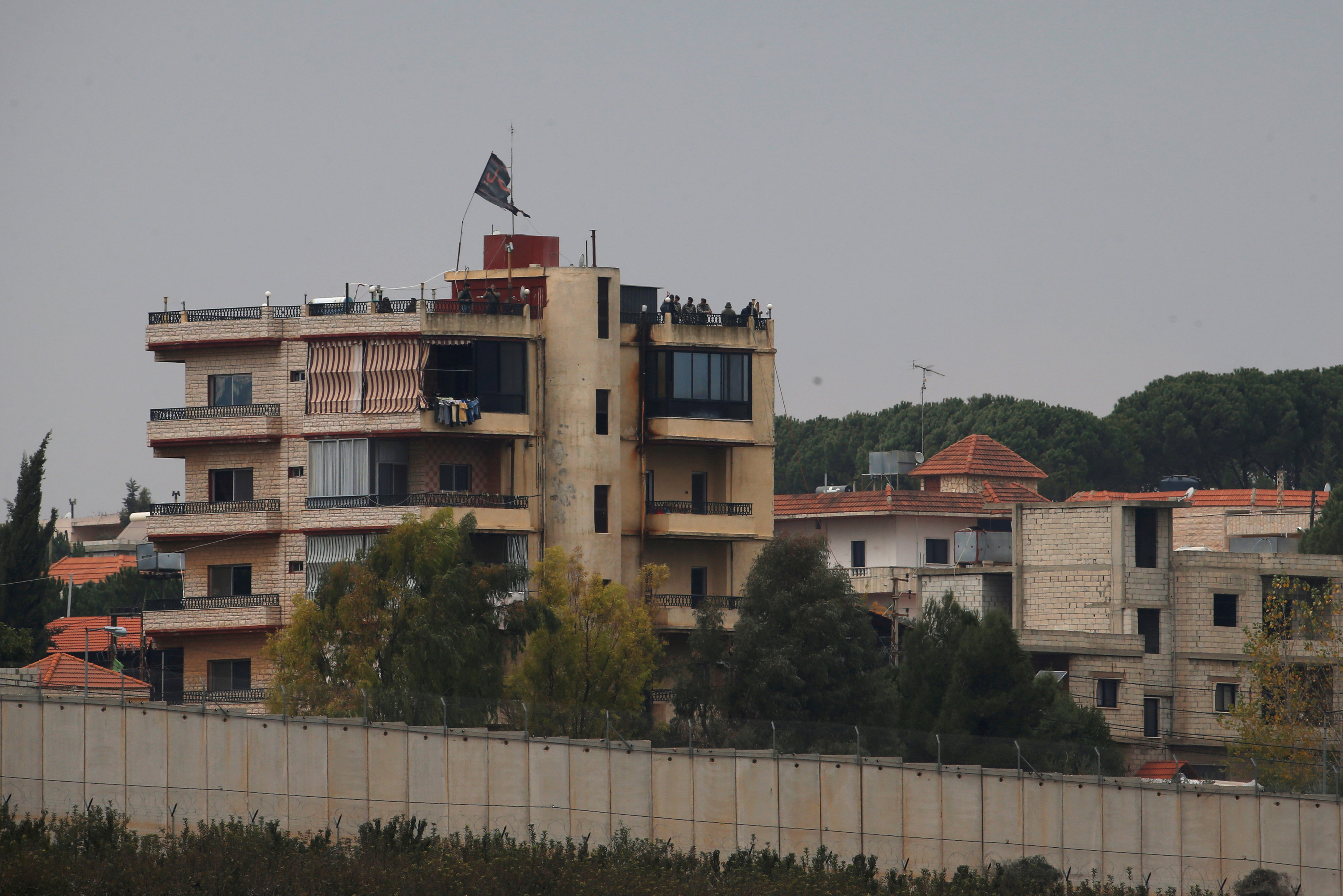 مواطنون يتابعون التطورات فوق أسطح أحد المنازل