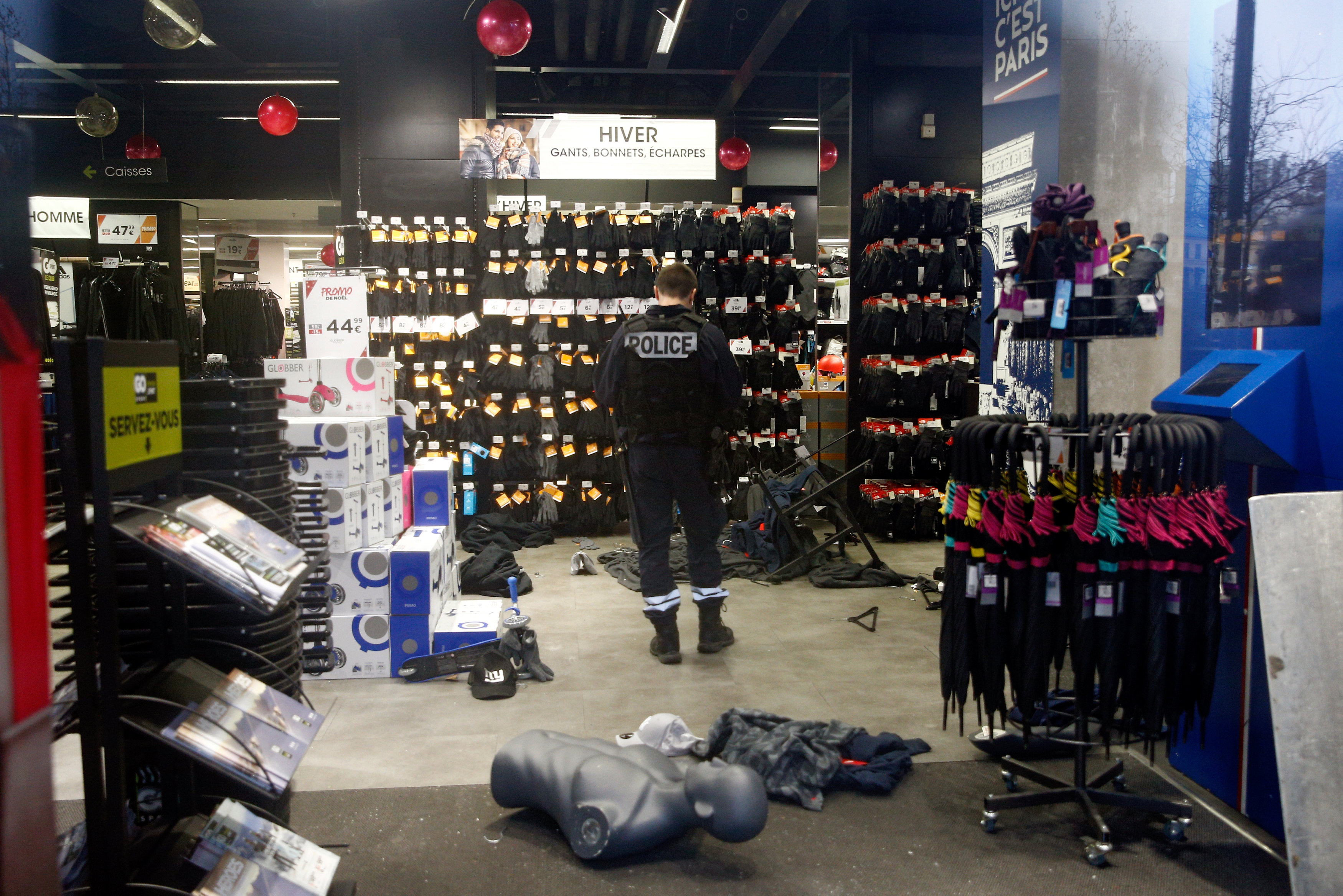 شرطى يرصد الدمار الذى لحق بأحد المحال التجارية