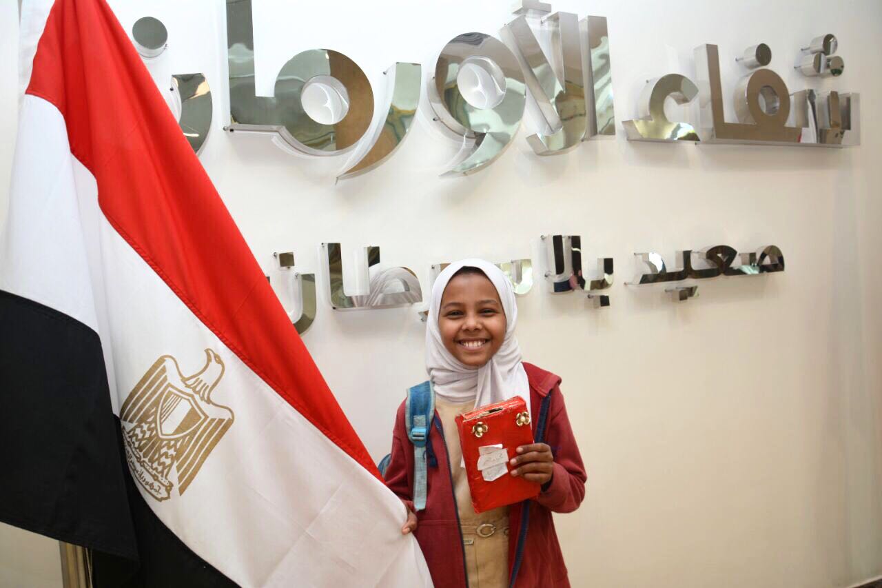 سعادة الطفلة بالتبرع وهى تحمل علم مصر