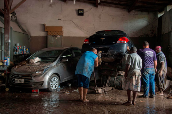 برازيليون يزيلون أثار الفيضانات
