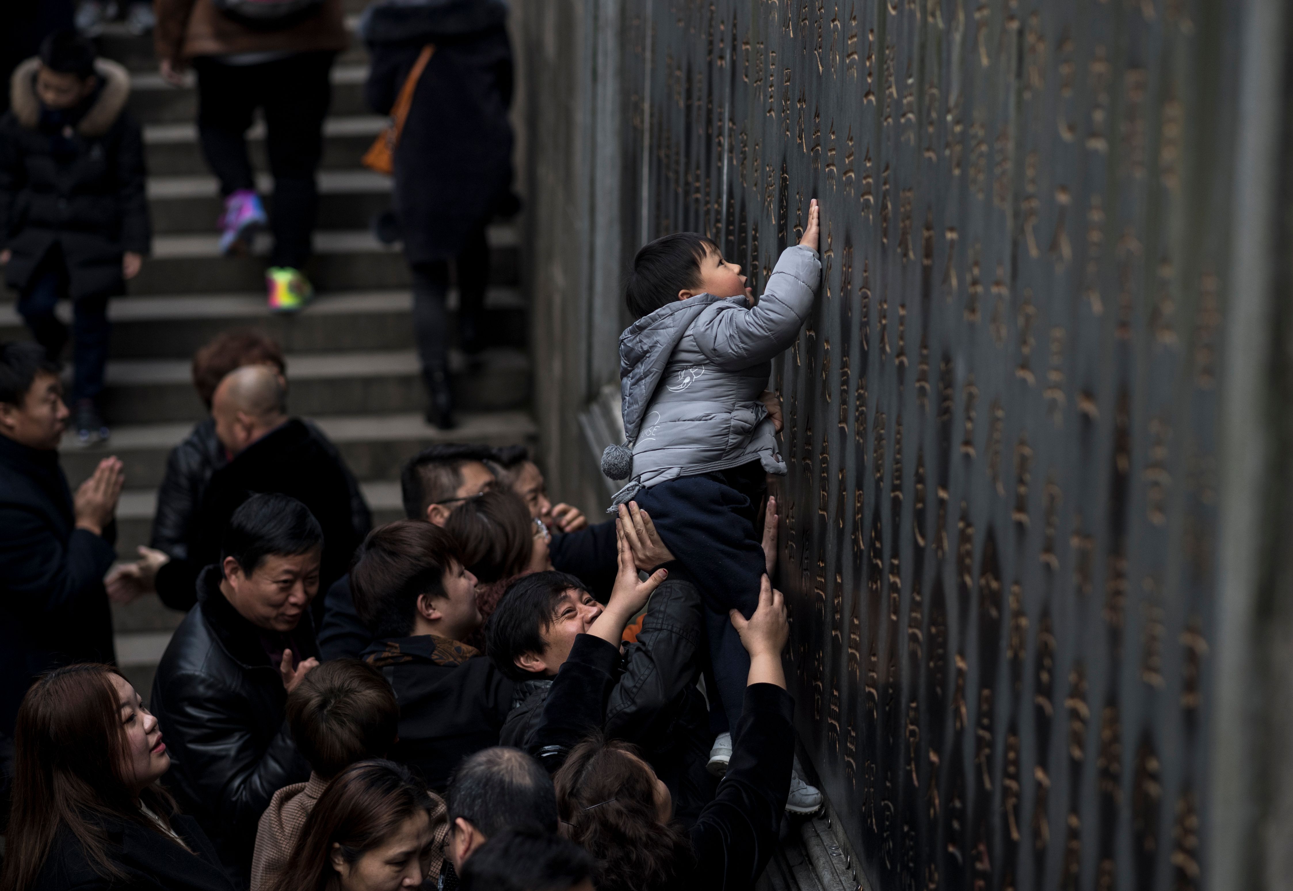 طفل يلامس حائط معبد بالصين لجلب الحظ للعام الجديد