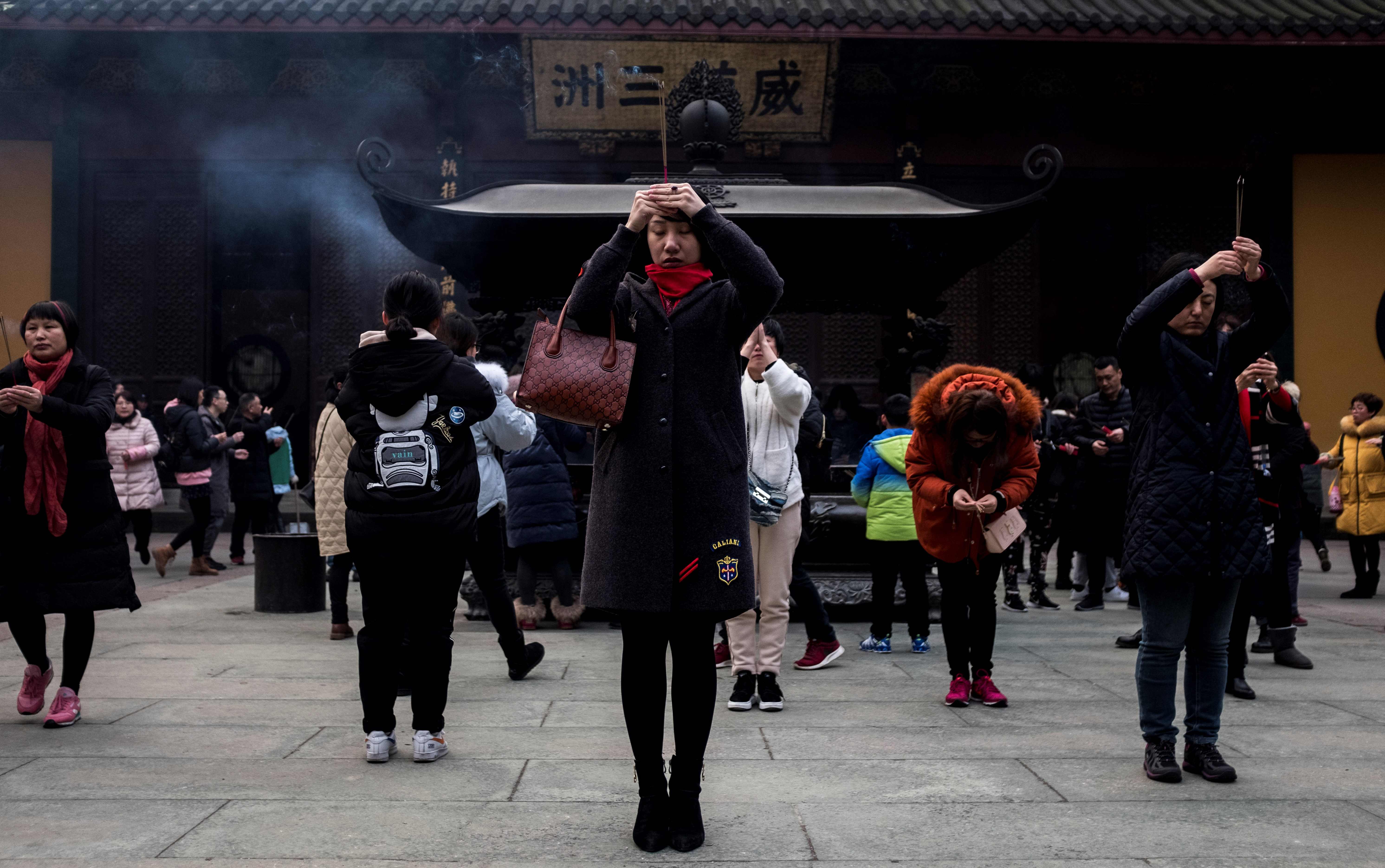 صينيون يؤدون طقوس دينية خاصة باحتفالات السنة الجديدة