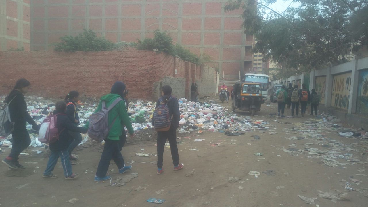 الطلاب يسيرون بجانب المخلفات والقمامة يوميا