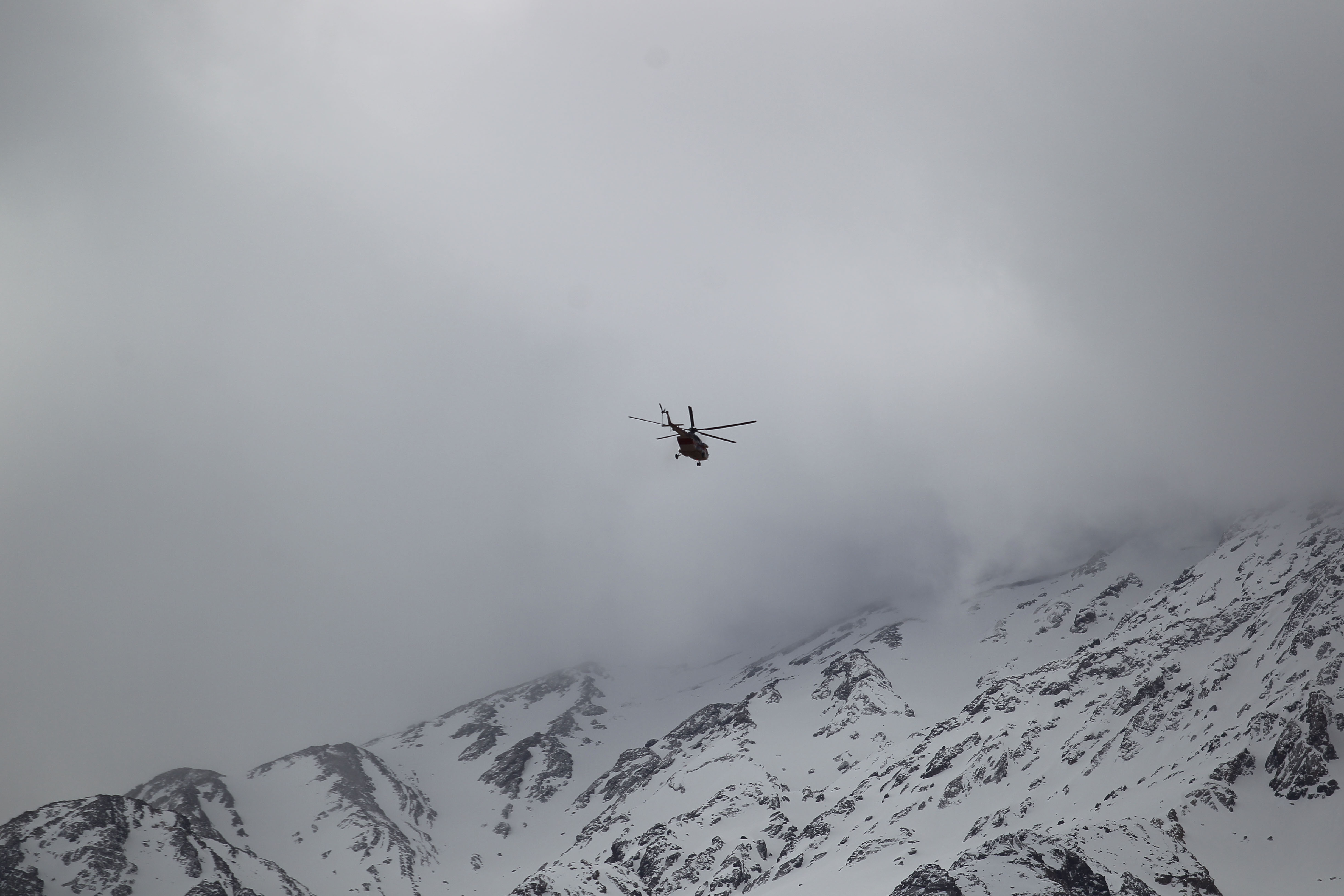 هليكوبتر تبحث بين الجبال عن الطائرة المفقودة
