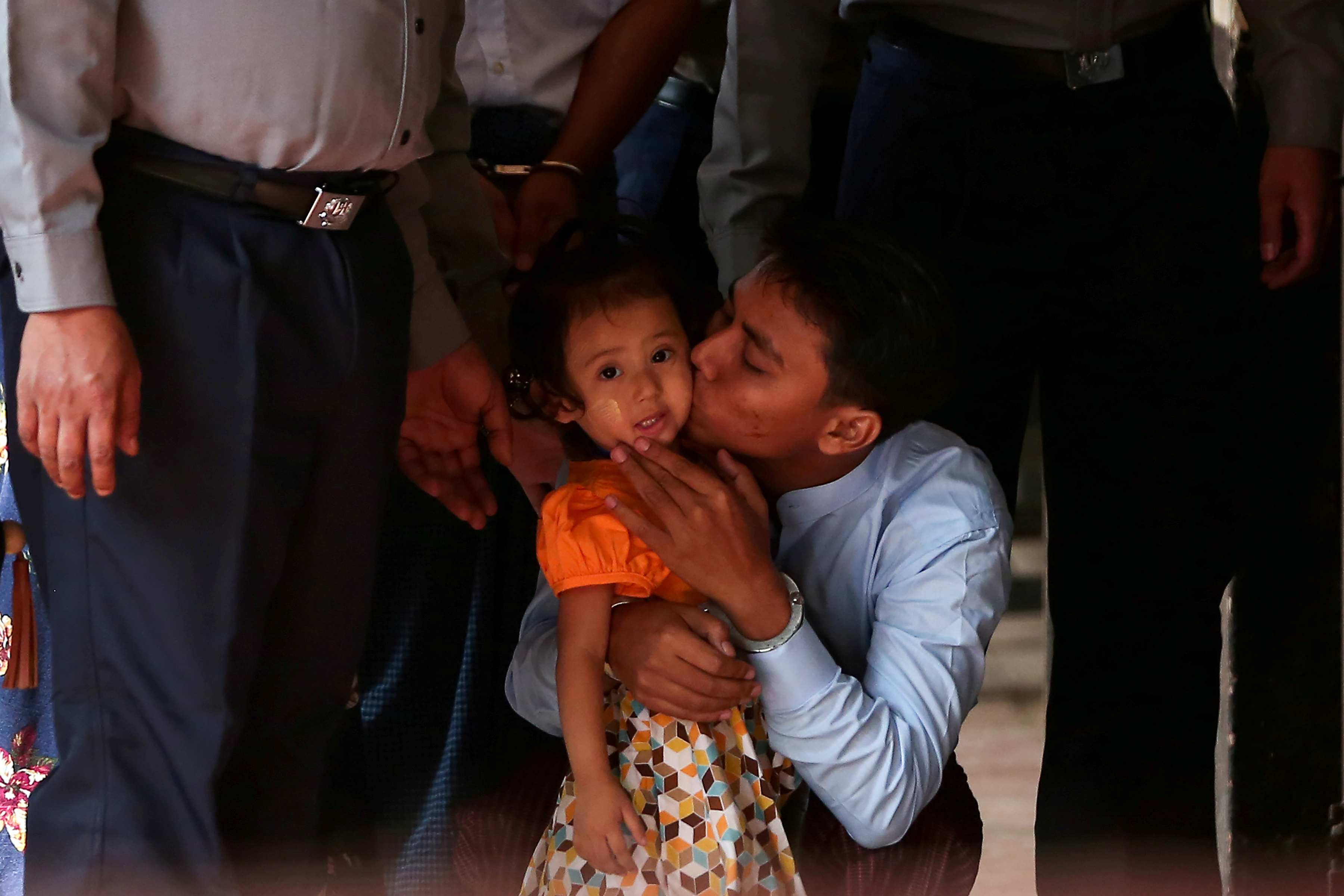 صحفى من رويترز يقبل ابنته قبل المثول أمام المحكمة