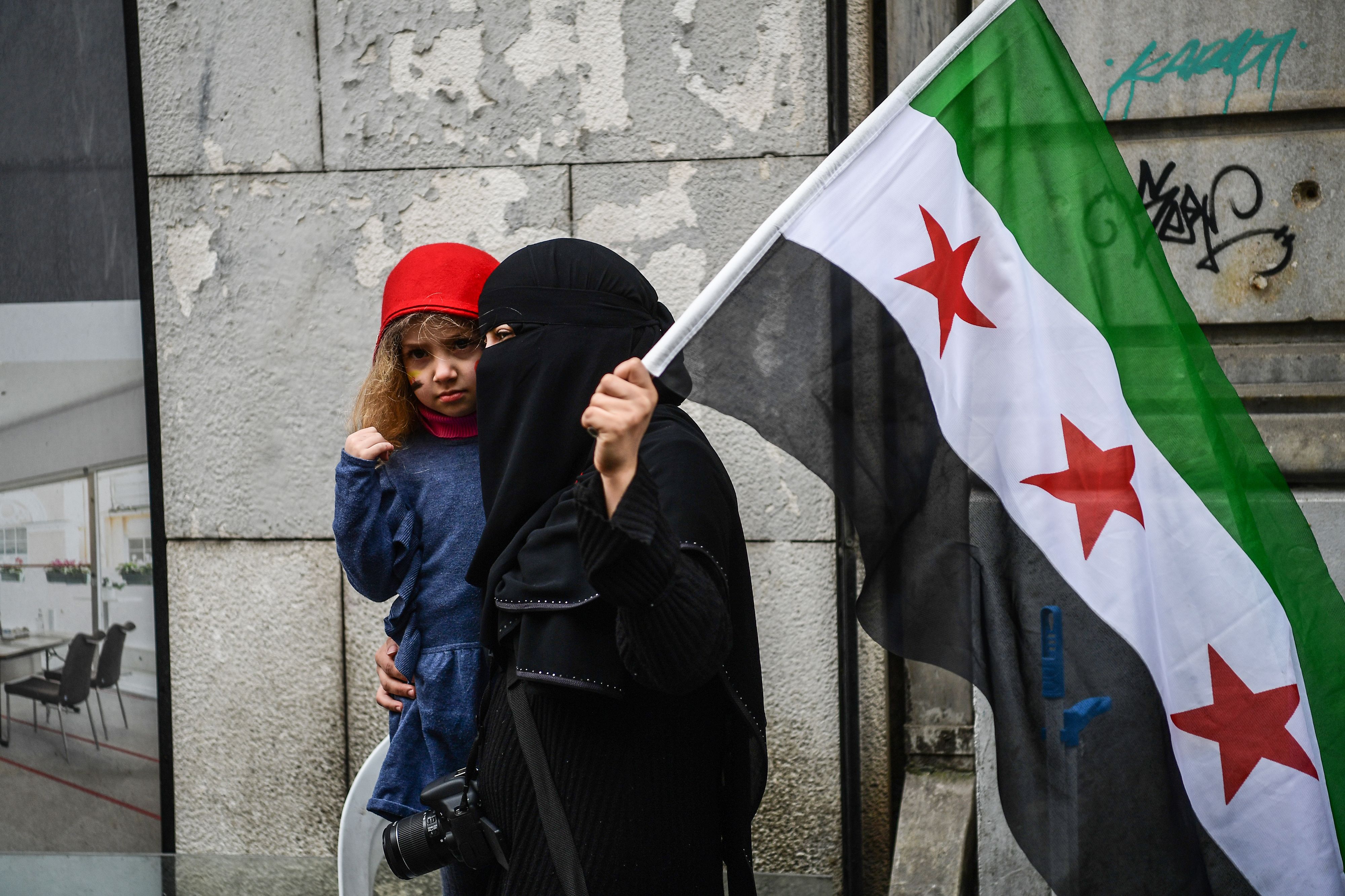 سيدة تحمل العلم السورى خلال الاحتجاجات