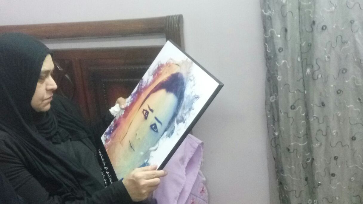 والدة فاطمة تحمل صورة ابنتها