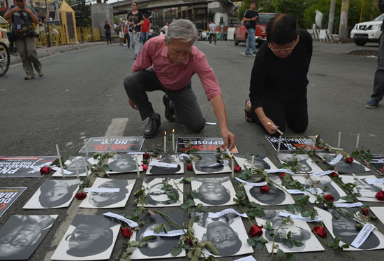 ورود وشموع على صور ضحايا الثورة الفلبينية