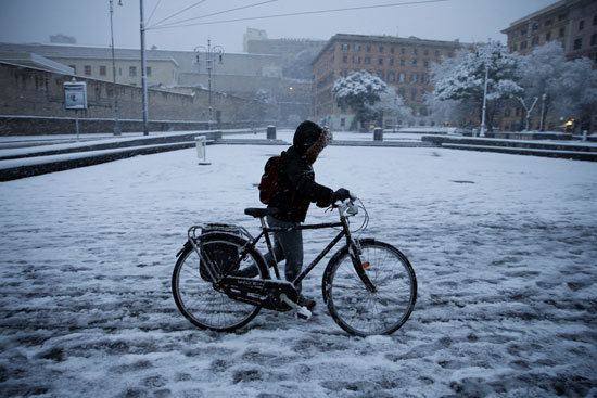 شاب يتجول بدراجته وسط الثلوج فى روما