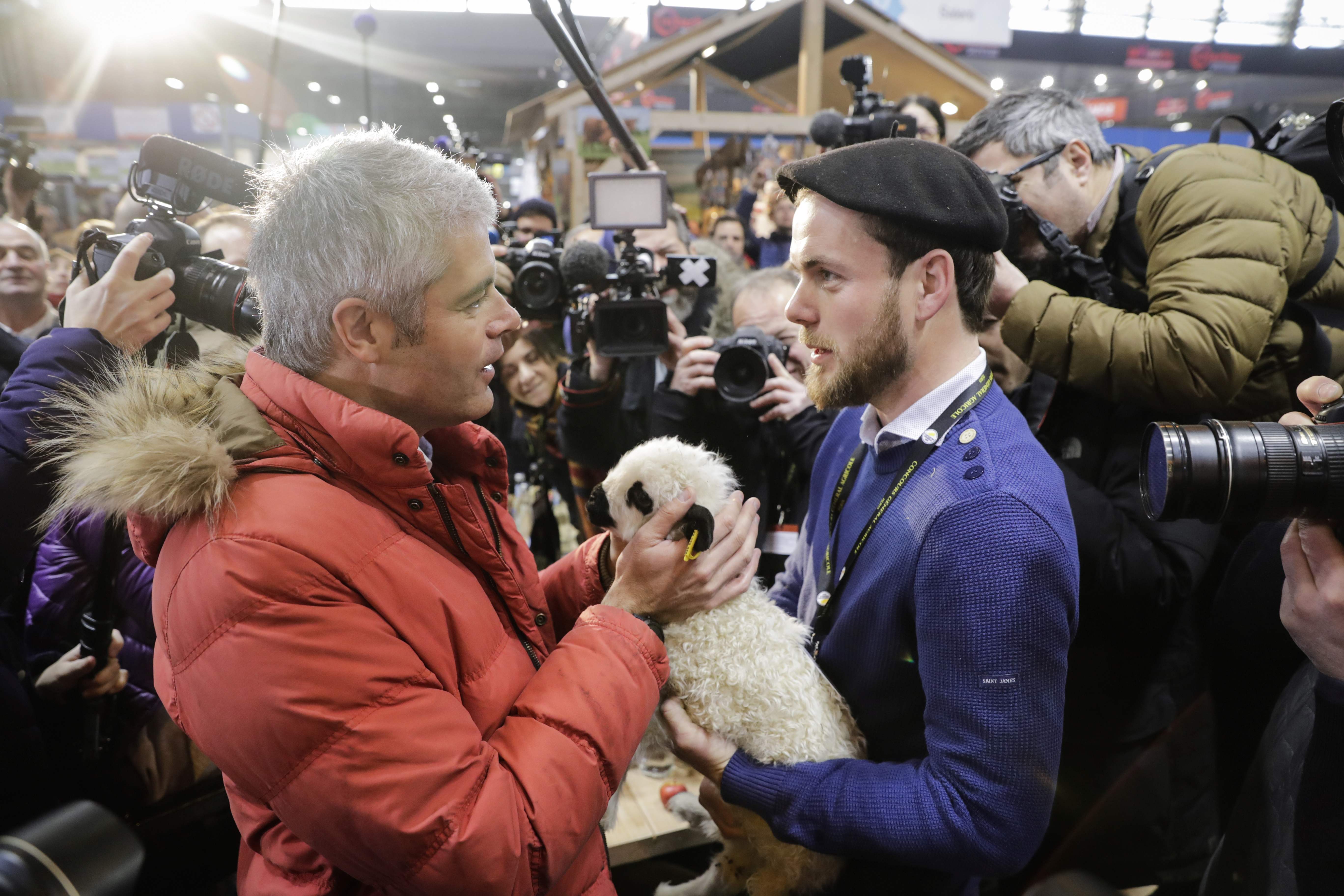 زعيم المعارضة اليمينى الفرنسى يداعب حيوان صغير بالمعرض