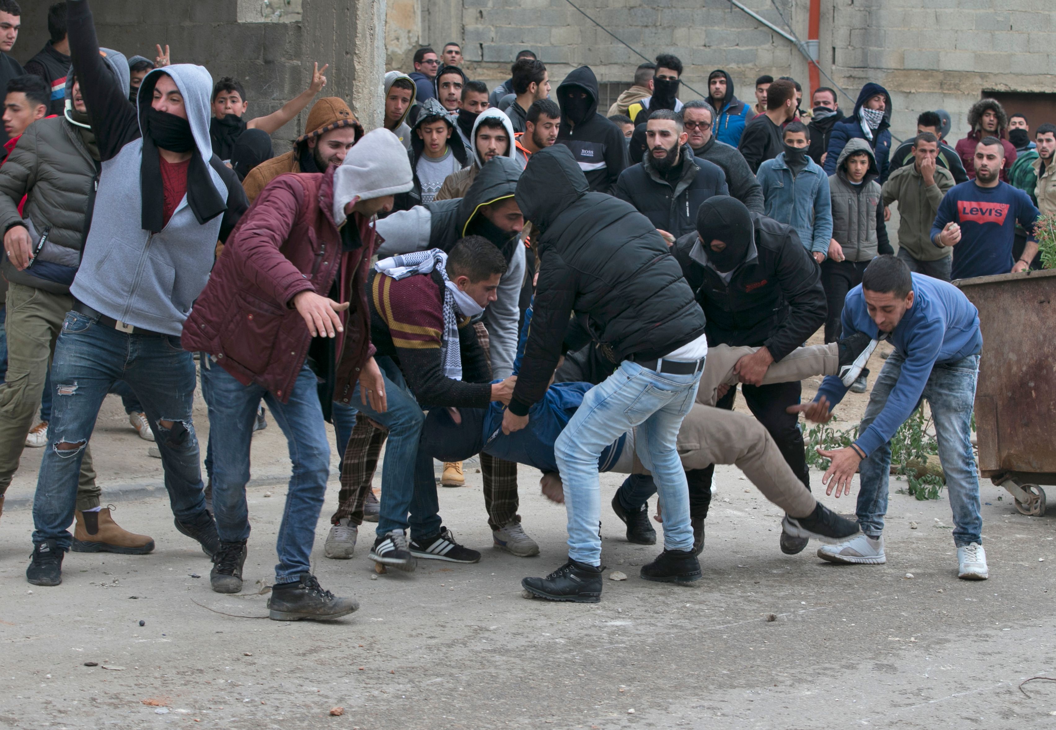 متظاهرون فلسطينيون ينقلون زميلهم المصاب خلال مواجهة الاحتلال