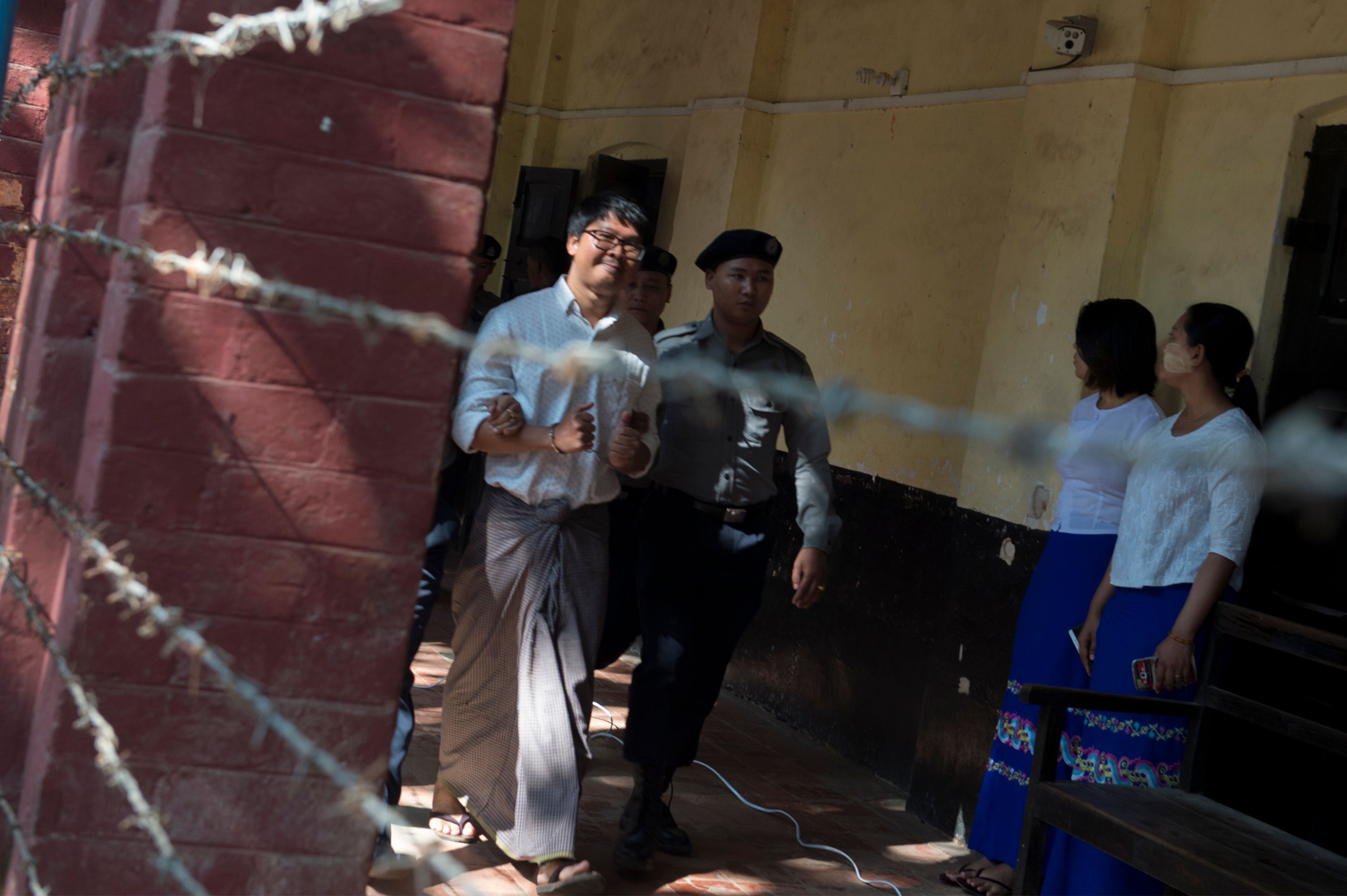 صحفى رويترز يبتسم للكاميرات قبل محاكمته فى ميانمار
