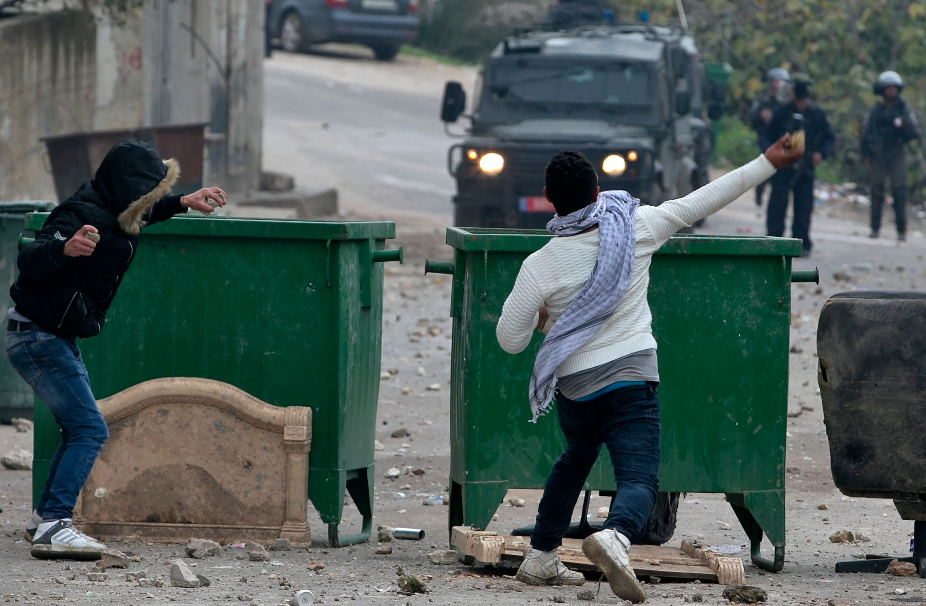شباب فلسطينى يلقى الحجارة صوب قوات الاحتلال