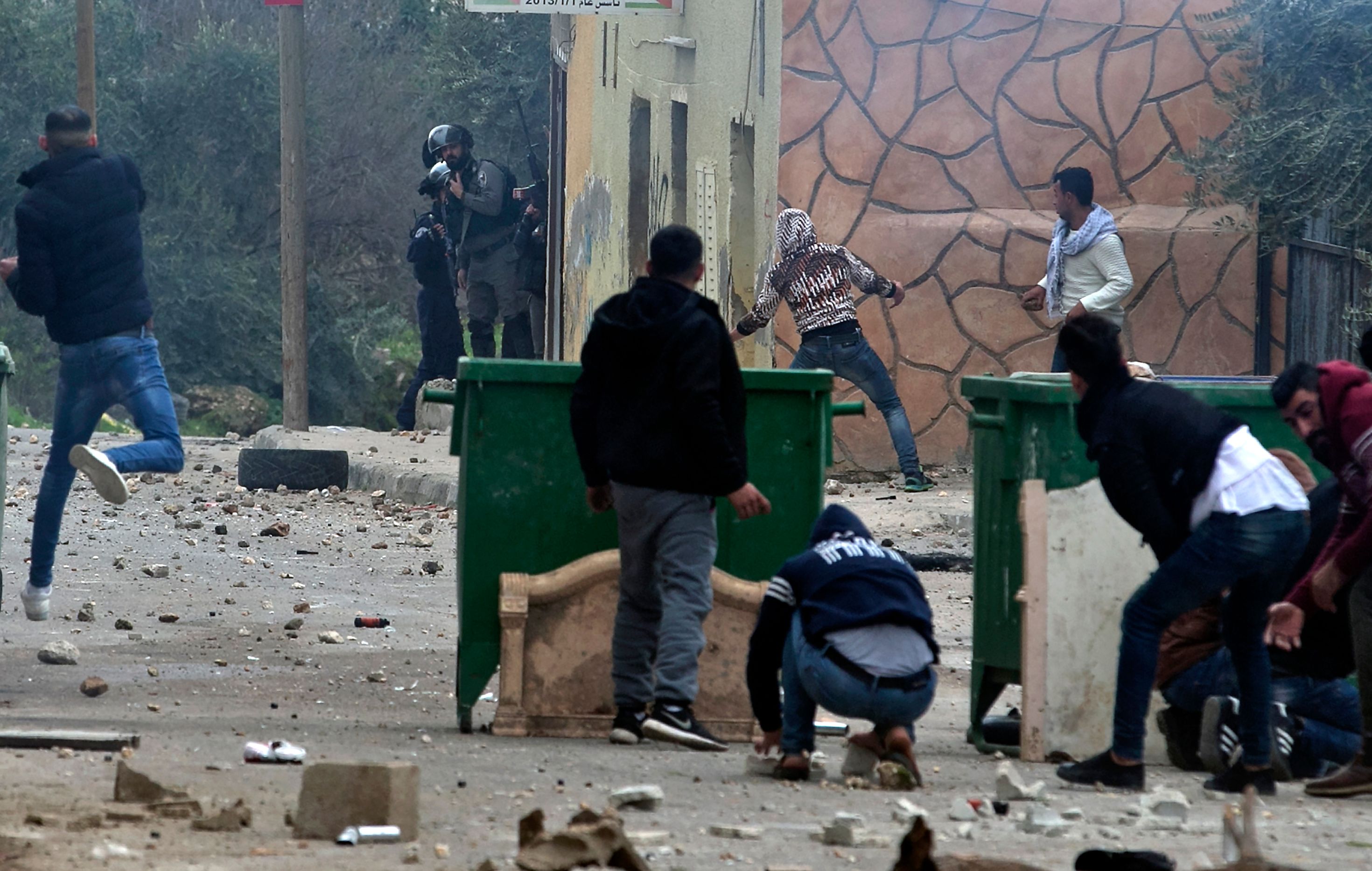 شباب فلسطينى يلقى الحجارة صوب قوات الاحتلال