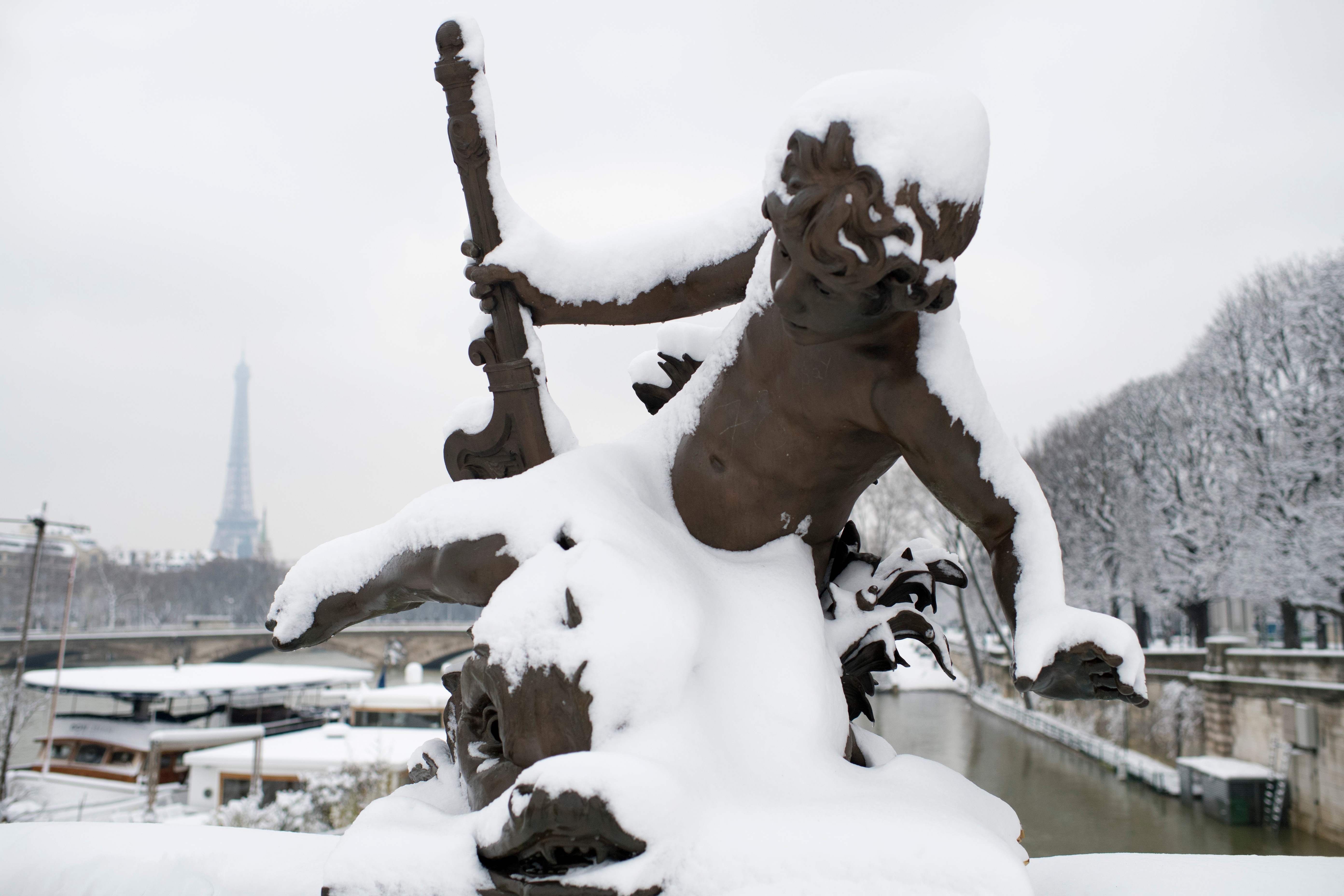الثلج يغطى تمثال فى أحد شوارع باريس