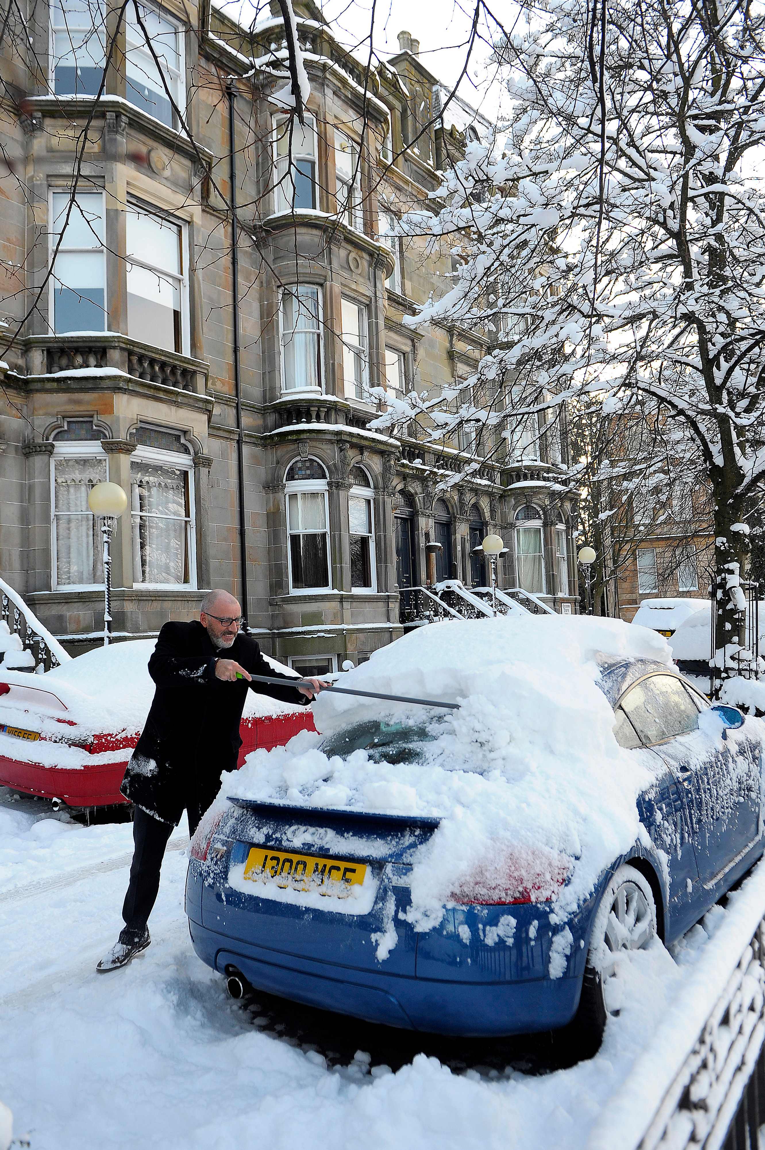 مواطن بريطانى يحاول إزالة الثلوج فى بريطانيا