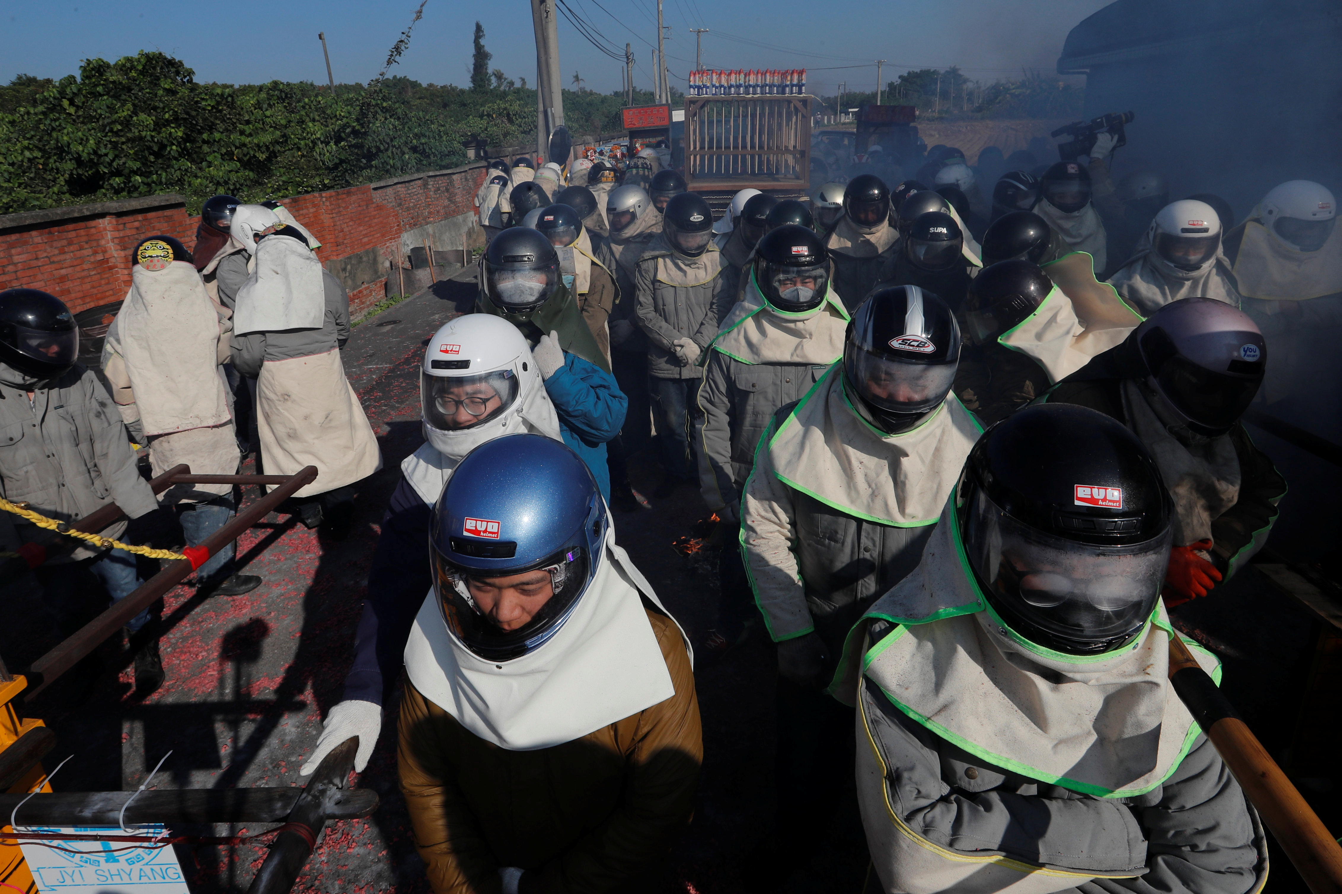 مواطنون يرتدون خوذ لحمايتهم من رذاذ الألعاب النارية