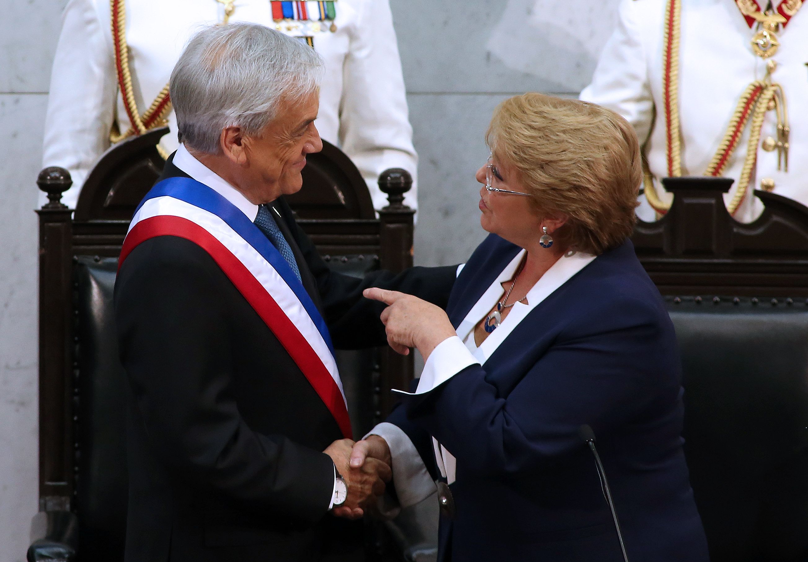 سيباستيان بينيرا الرئيس الجديد يصافح الرئيسة السابقة