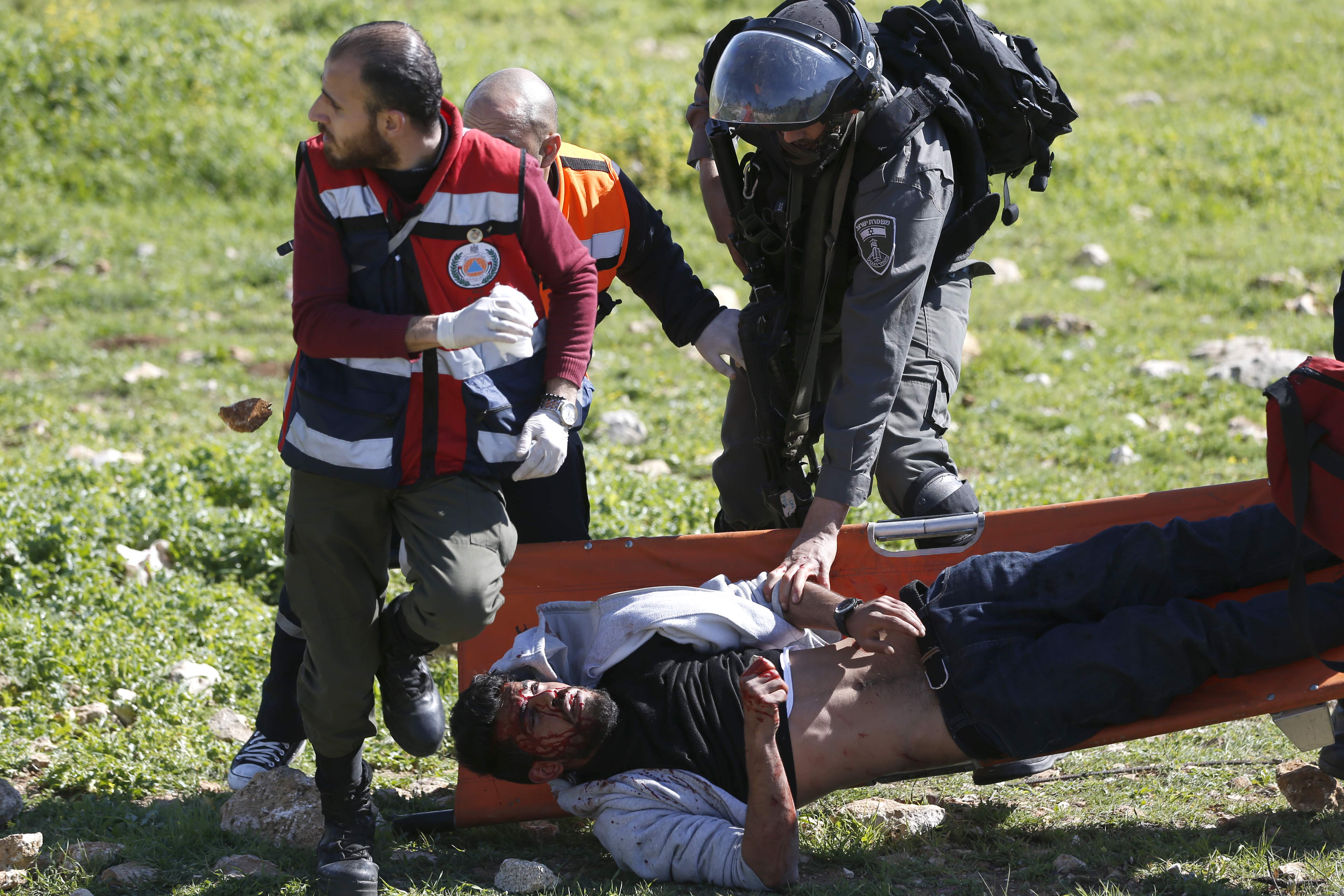 أحد جنود الاحتلال يعتدى على الفلسطينى المصاب