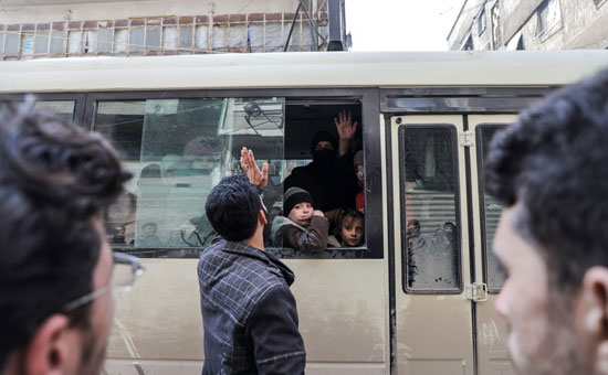 شاب سورى يودع الأطفال قبل مغادرتهم الغوطة الشرقية