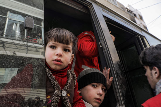 طفل سورى ينظر من نافذة حافلة قبل مغاردته الغوطة الشرقية
