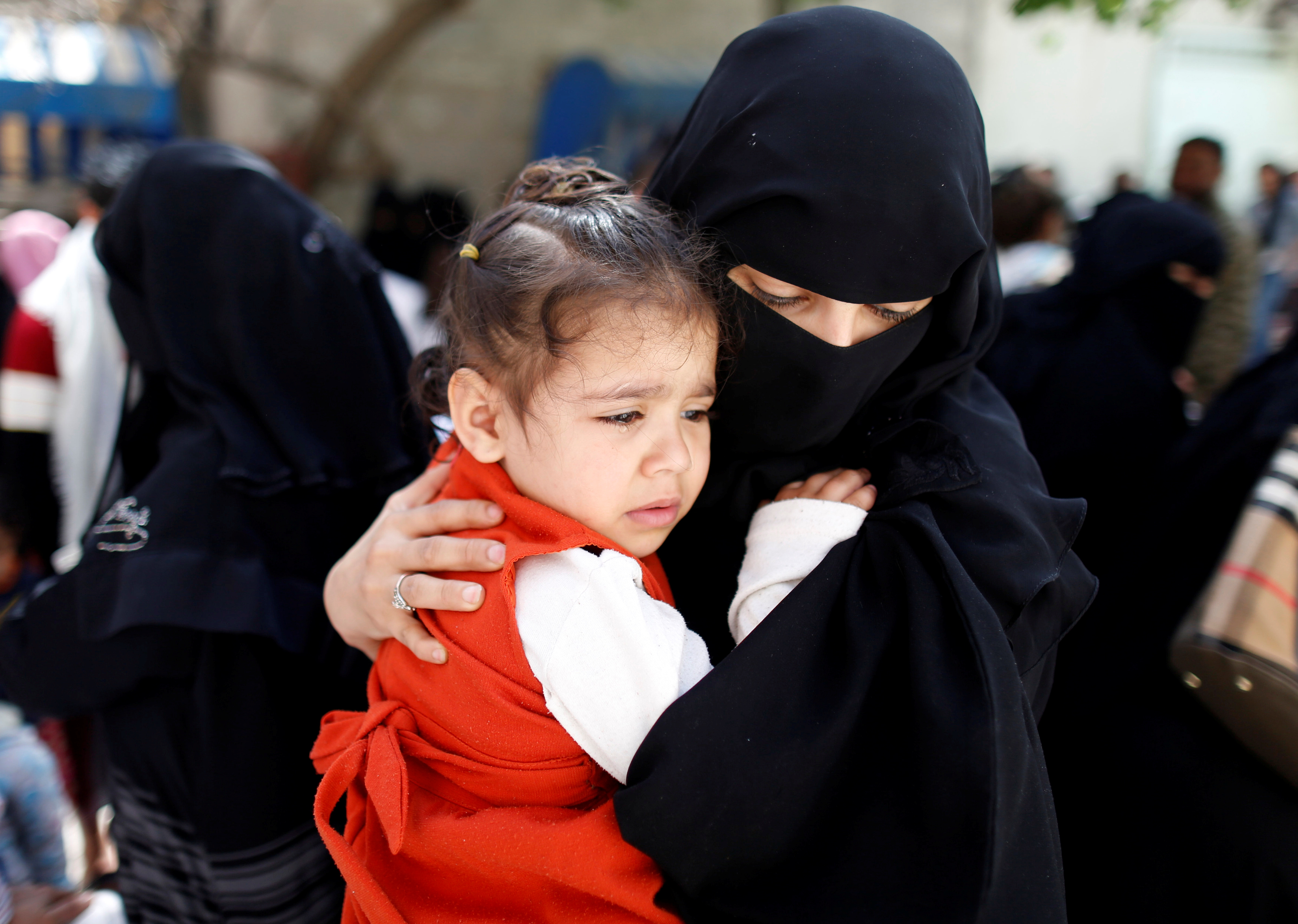 يمنية تحمل طفلتها للتطعيم