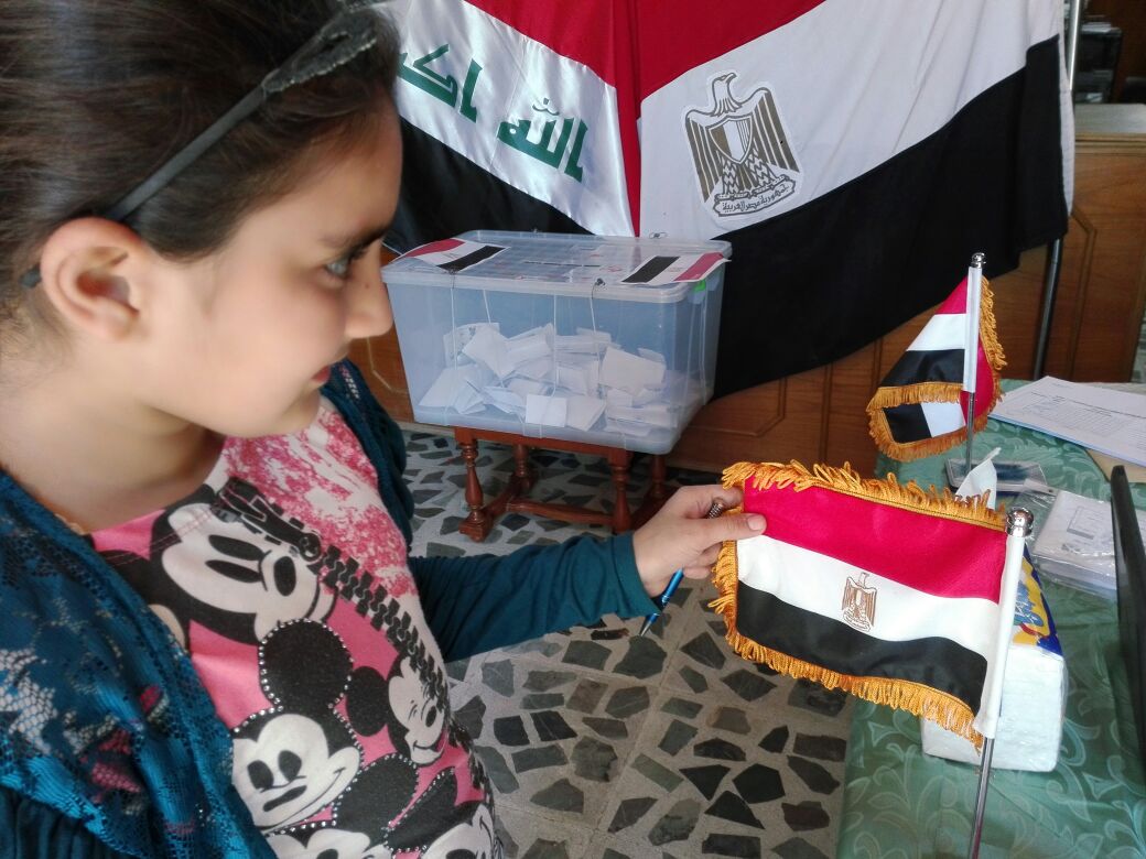 طلفة مصرية تحمل علم مصر داخل السفارة المصرية فى بغداد