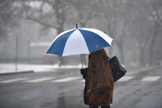 سيدة تحتمى بمظلة من الثلوج فى واشنطن