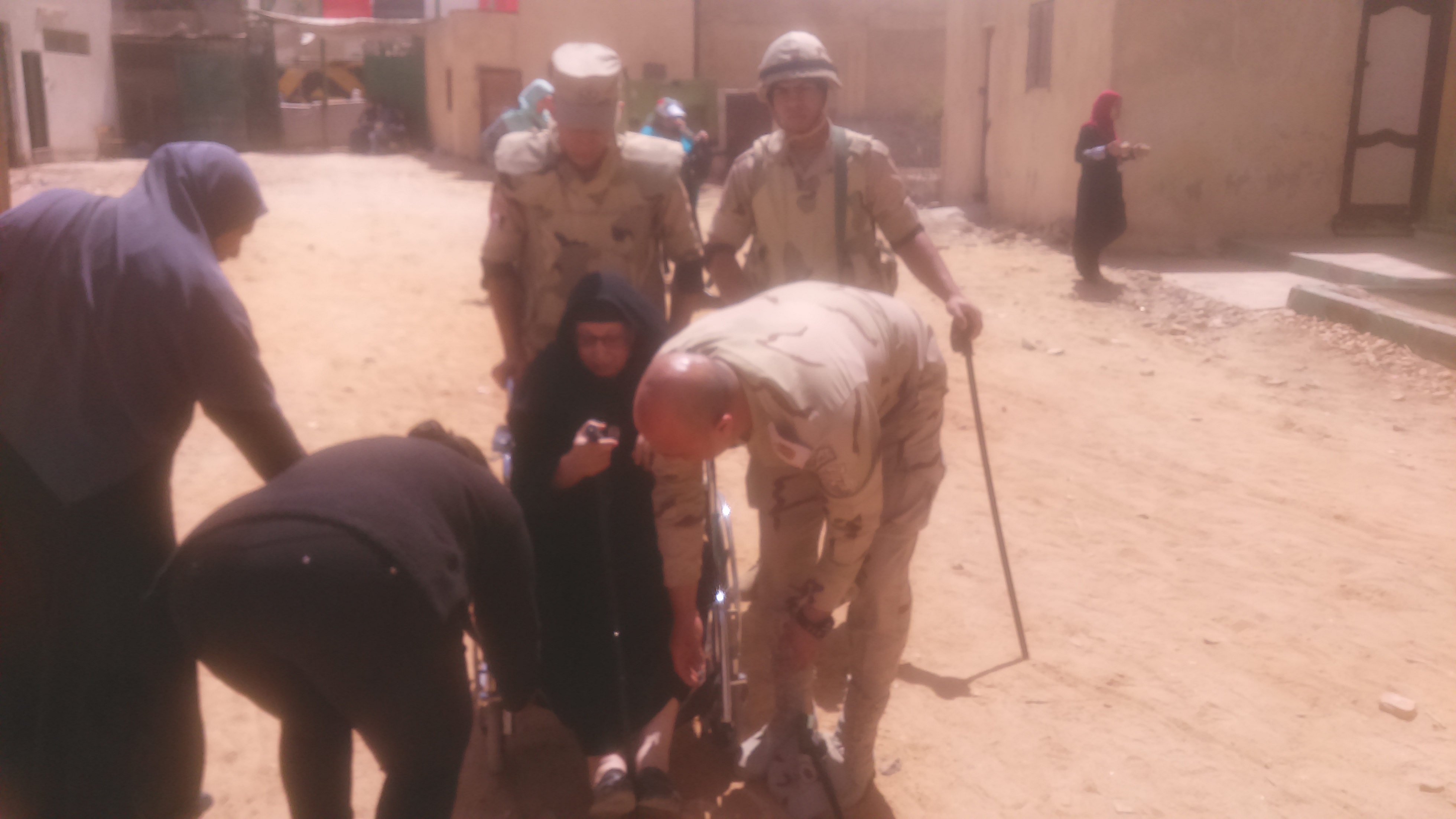 رجال الجيش يساعدون عجوز للإدلاء بصوتها فى حدائق حلوان (1)
