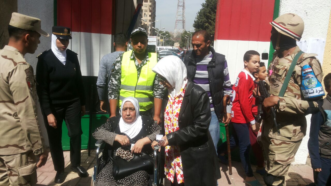 رجال الشرطة تساعد مسنة الوصول لمقر لجنتها الانتخابية  (2)