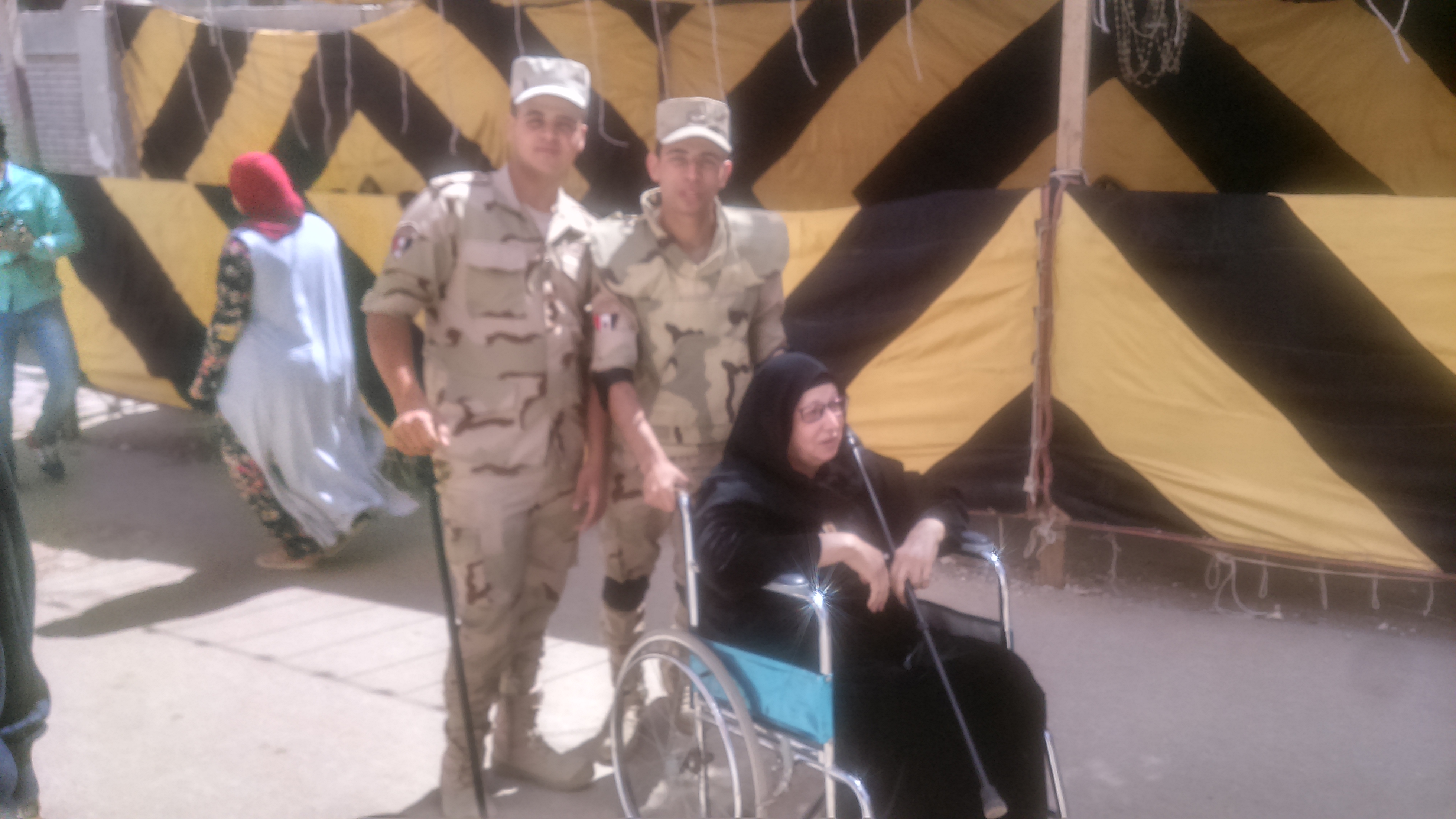 رجال الجيش يساعدون عجوز للإدلاء بصوتها فى حدائق حلوان (7)