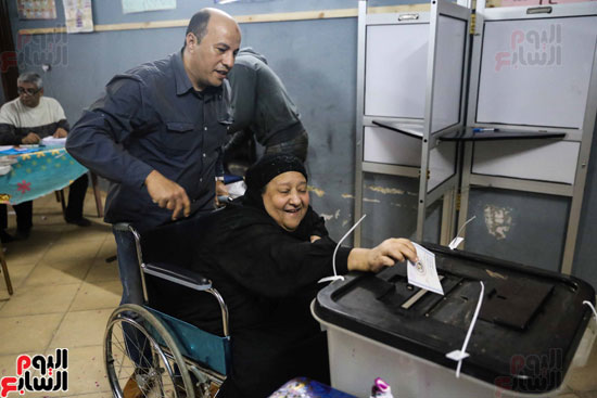 قوات تأمين اللجان تحمل مسنتين للإدلاء بأصواتهما فى القاهرة (1)
