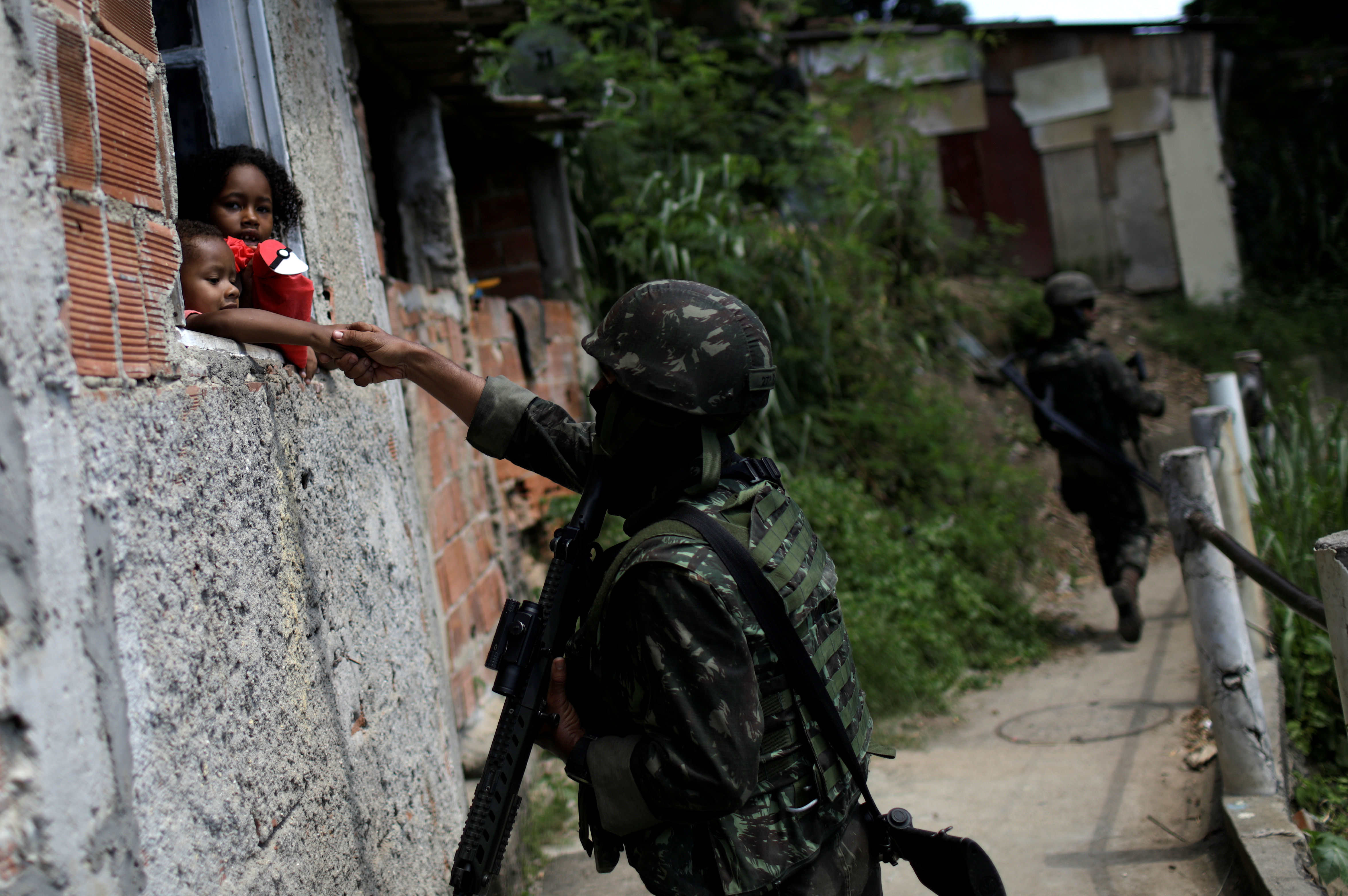 أحد عناصر الشرطة البرازيلية يصافح أحد الأطفال