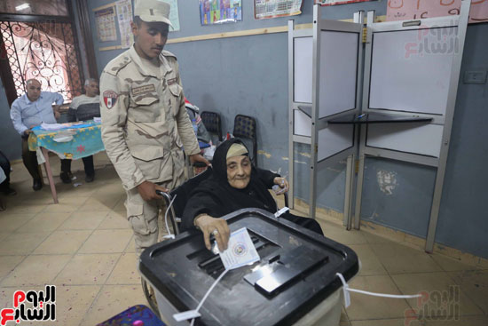 قوات تأمين اللجان تحمل مسنتين للإدلاء بأصواتهما فى القاهرة (6)