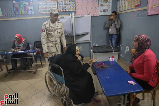 قوات تأمين اللجان تحمل مسنتين للإدلاء بأصواتهما فى القاهرة (7)