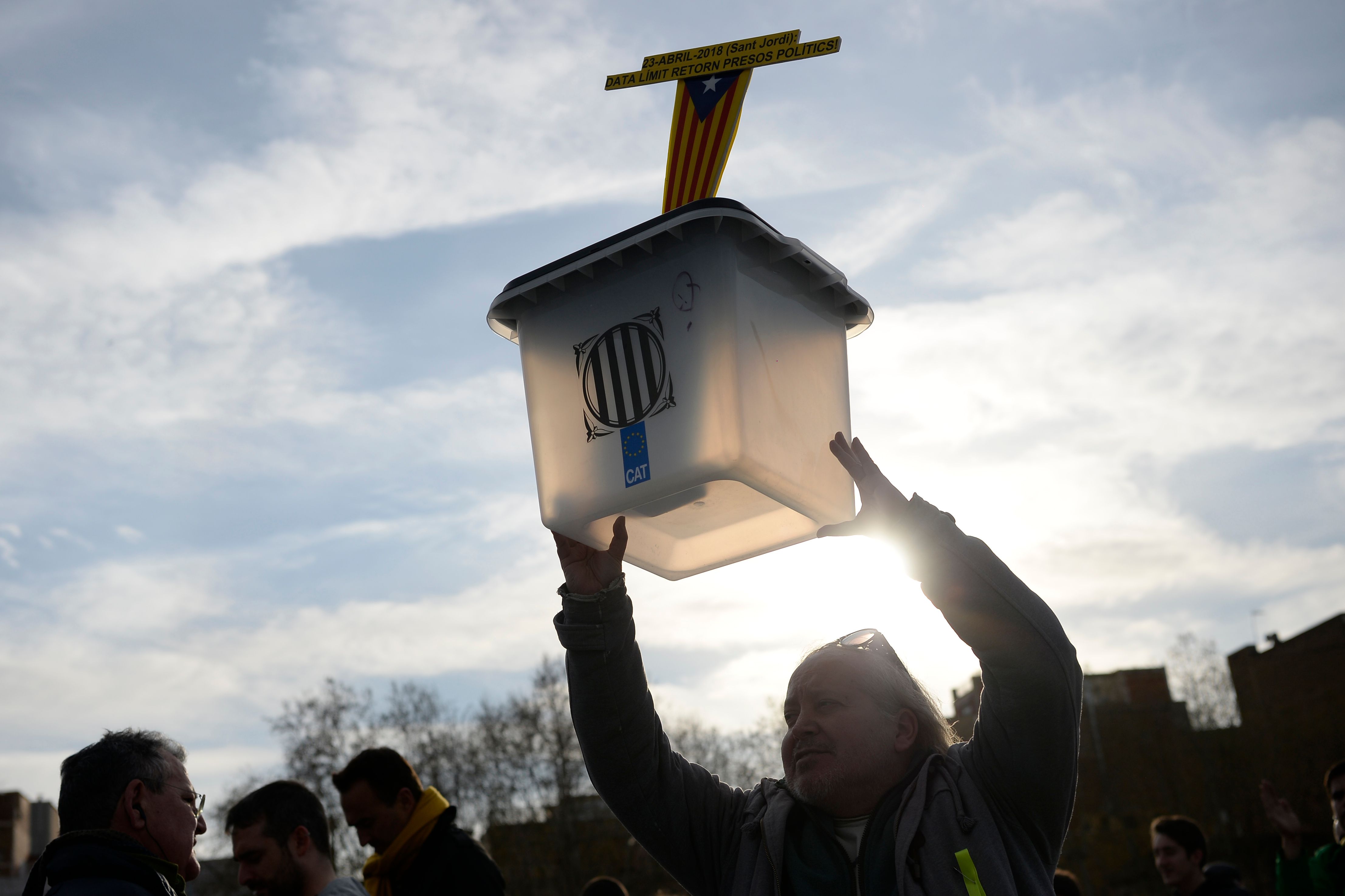 أحد  المتظاهرين يرفع صندوق انتخالى تحت علم كتالونيا