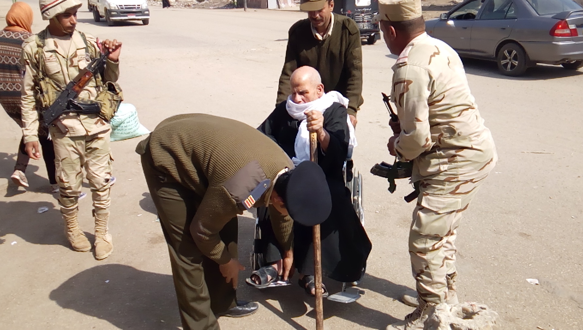 صور على كرسي متحرك رجال الجيش يساعدون مُسن للإدلاء بصوته  بمنيا القمح (4)