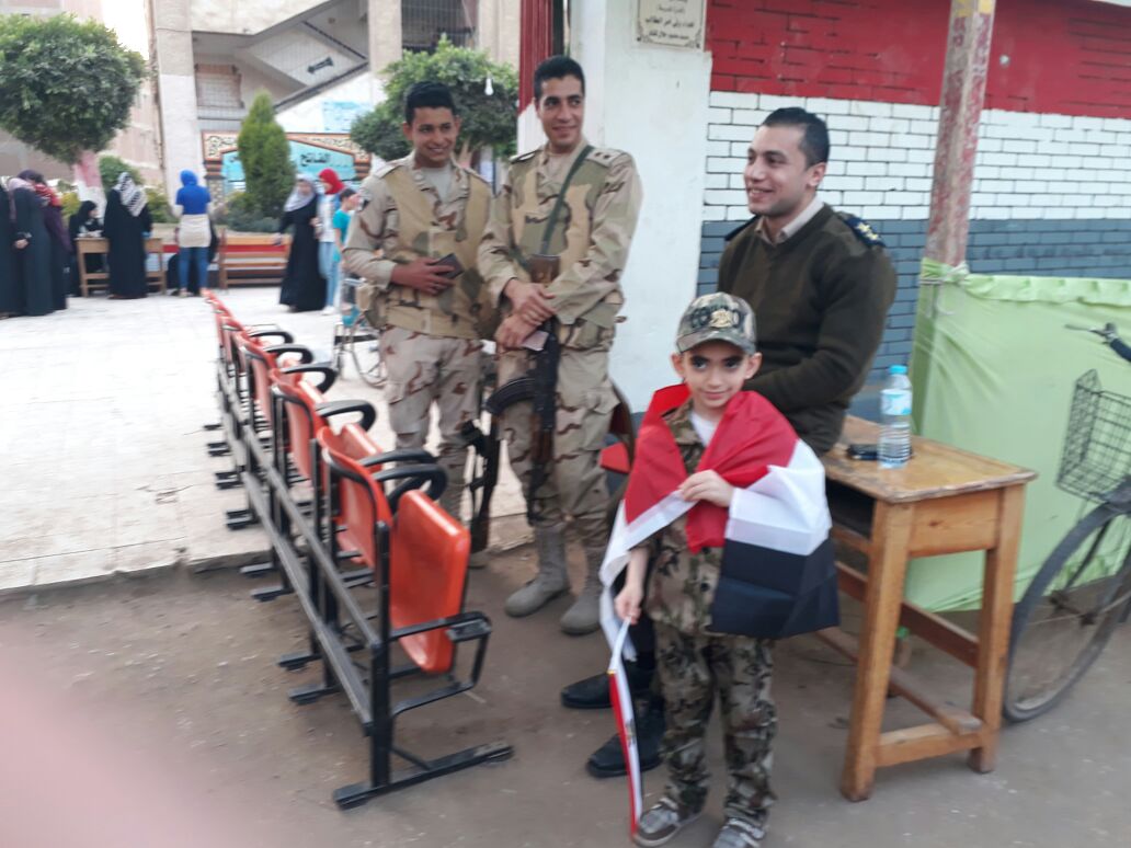 طفل يرتدى الزى العسكرى ويحمل على كتفة علم مصر